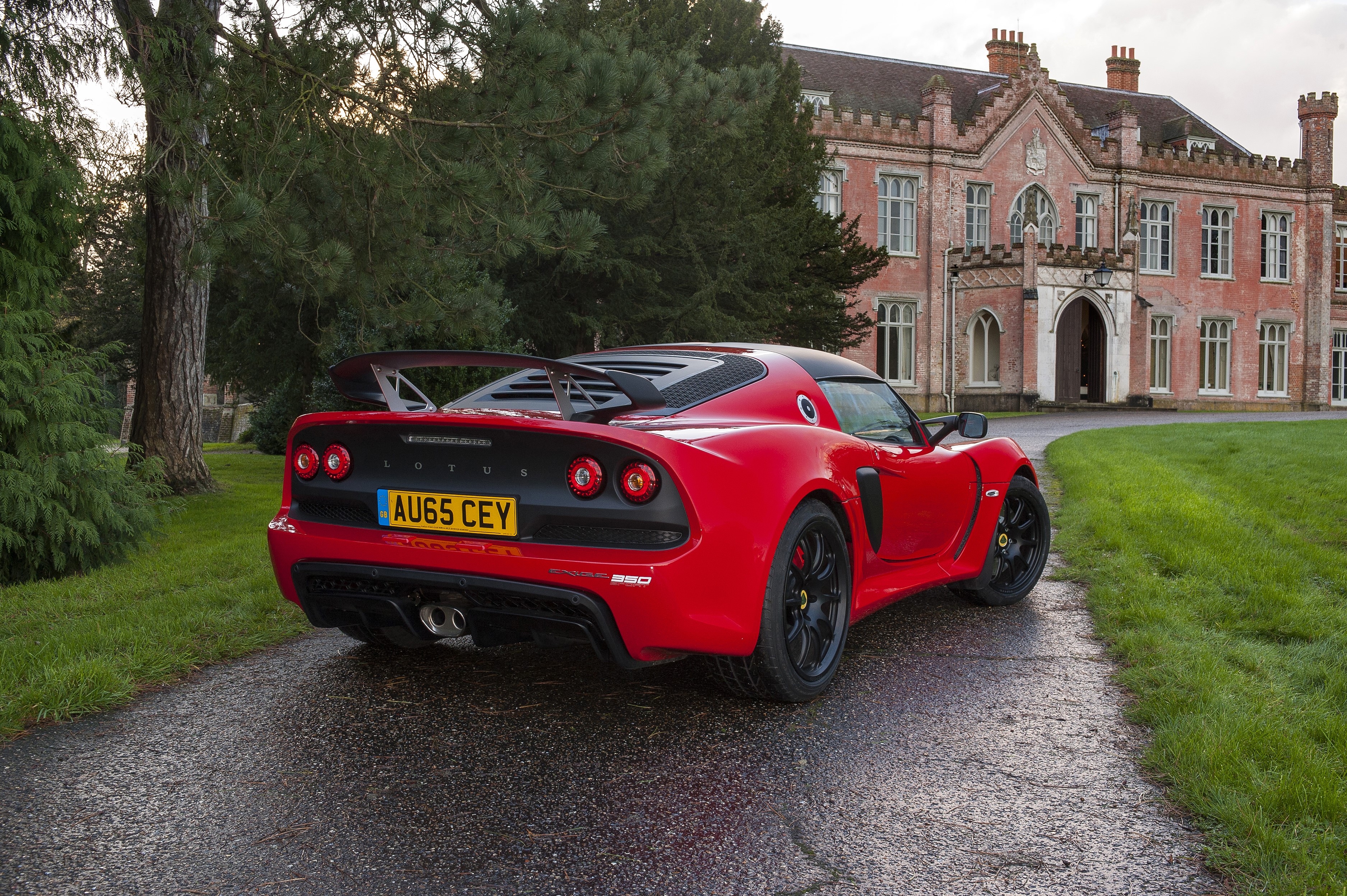 Red Lotus Exige Sport 350 parked in front of a historic building HD Wallpaper