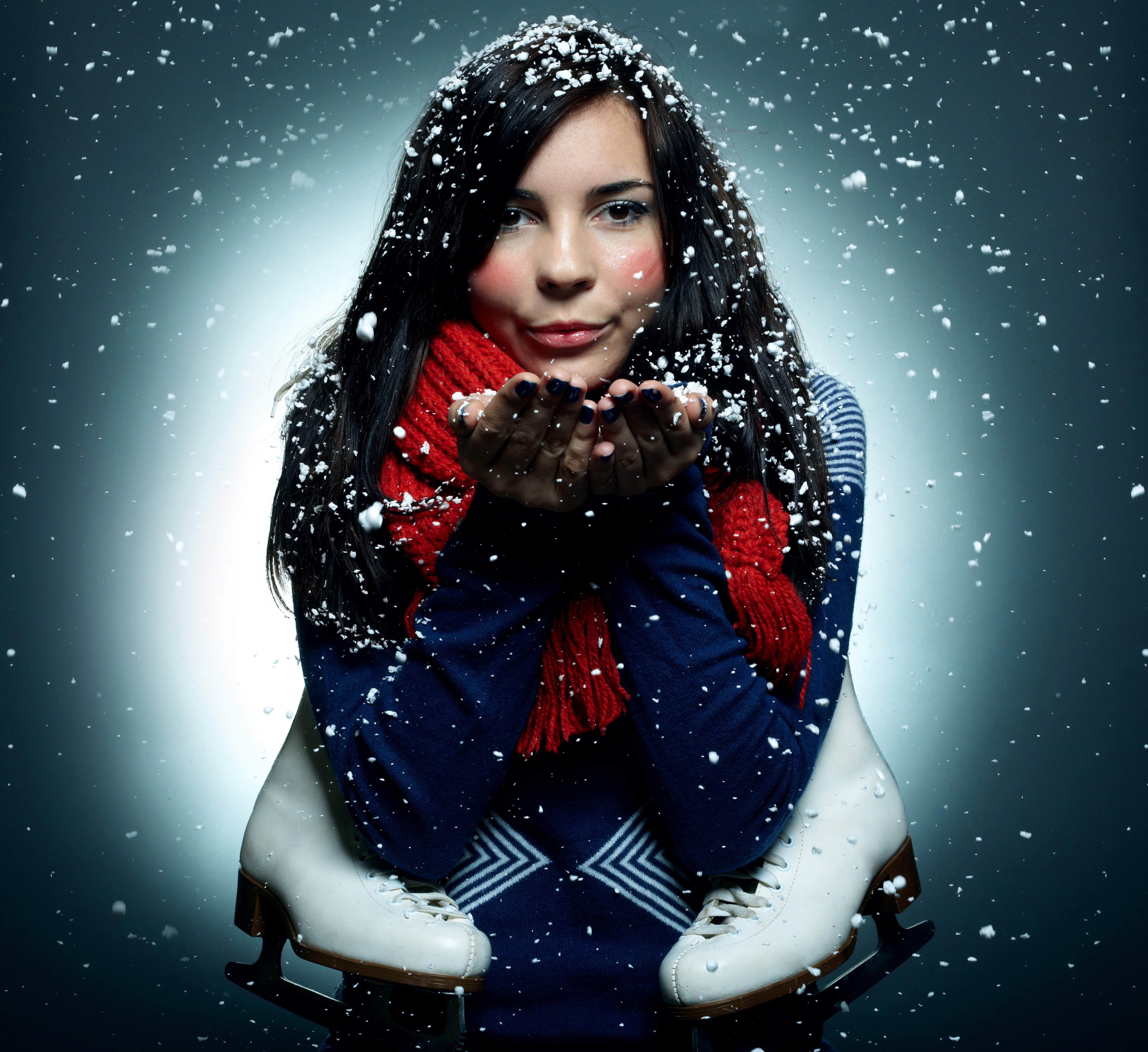 Brunette girl blowing snowflakes with ice skates HD Wallpaper