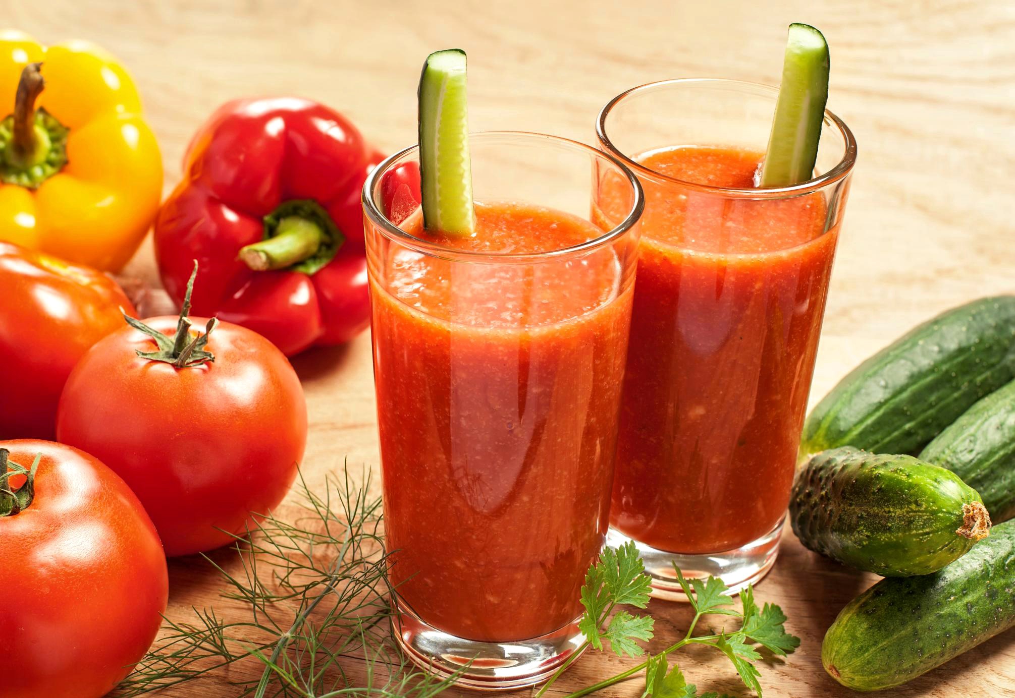 Two glasses of tomato juice with cucumber garnish and fresh vegetables HD Wallpaper