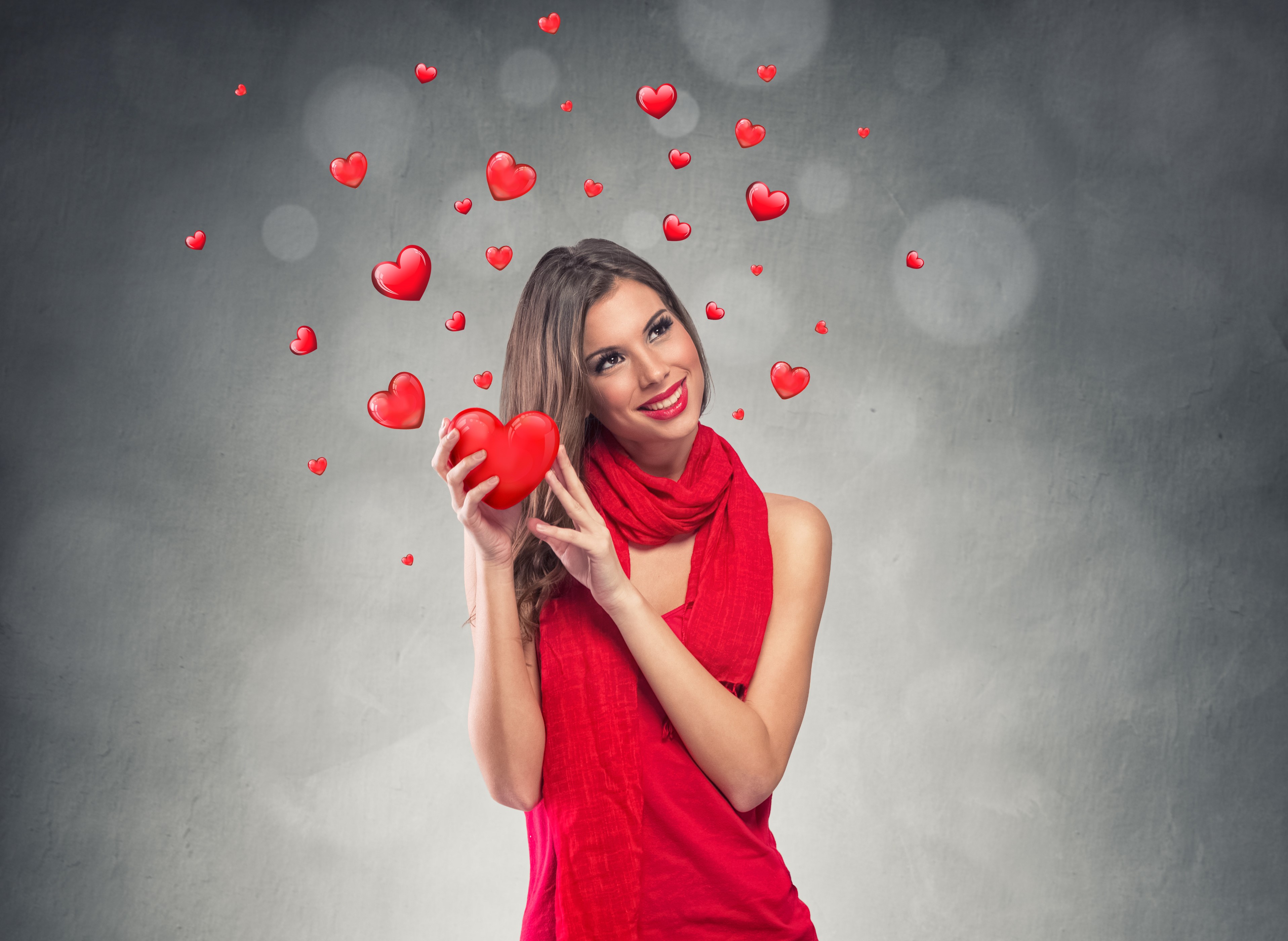 Woman holding a red heart with hearts floating around her HD Wallpaper
