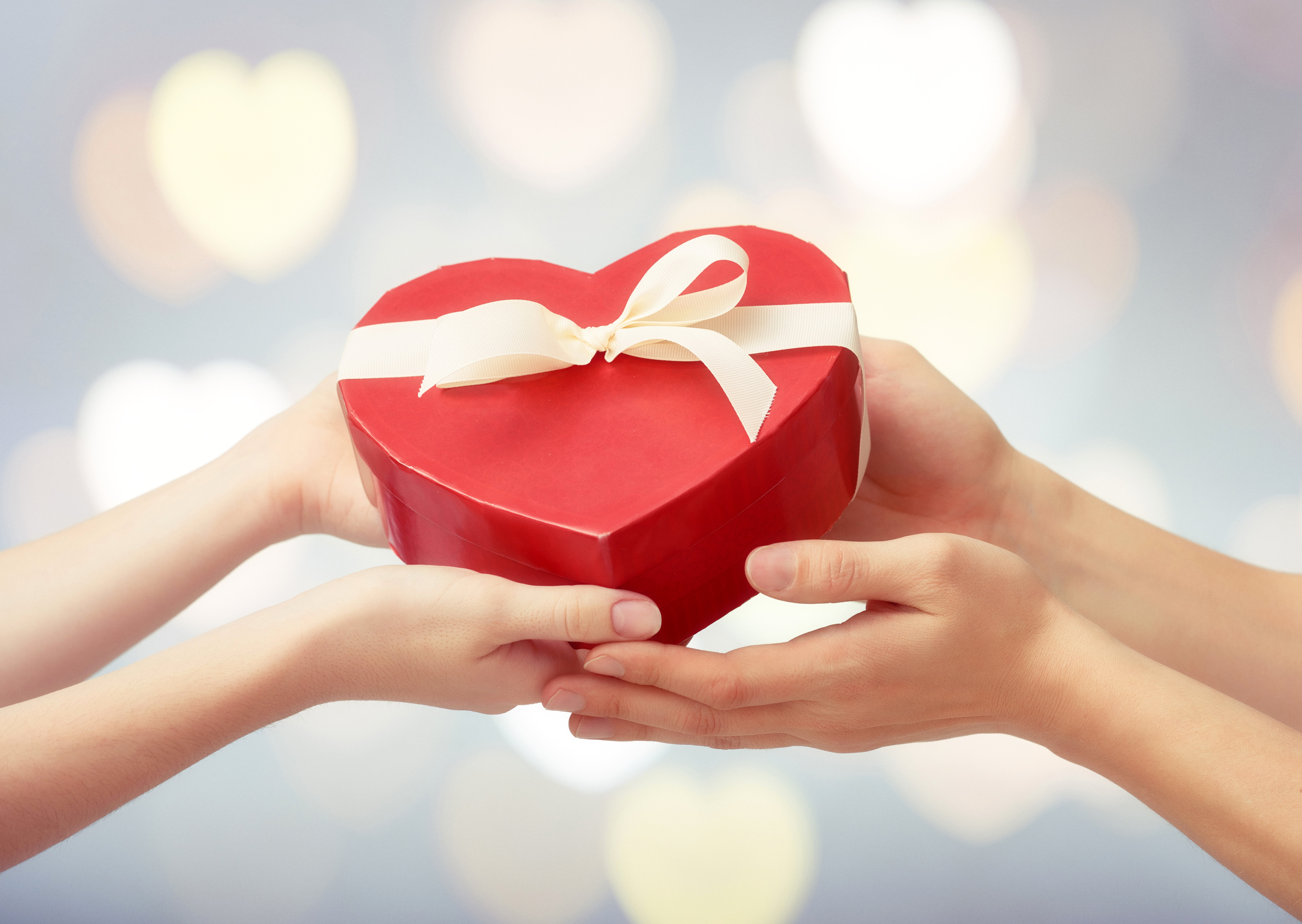 Hands exchanging a heart-shaped gift box HD Wallpaper