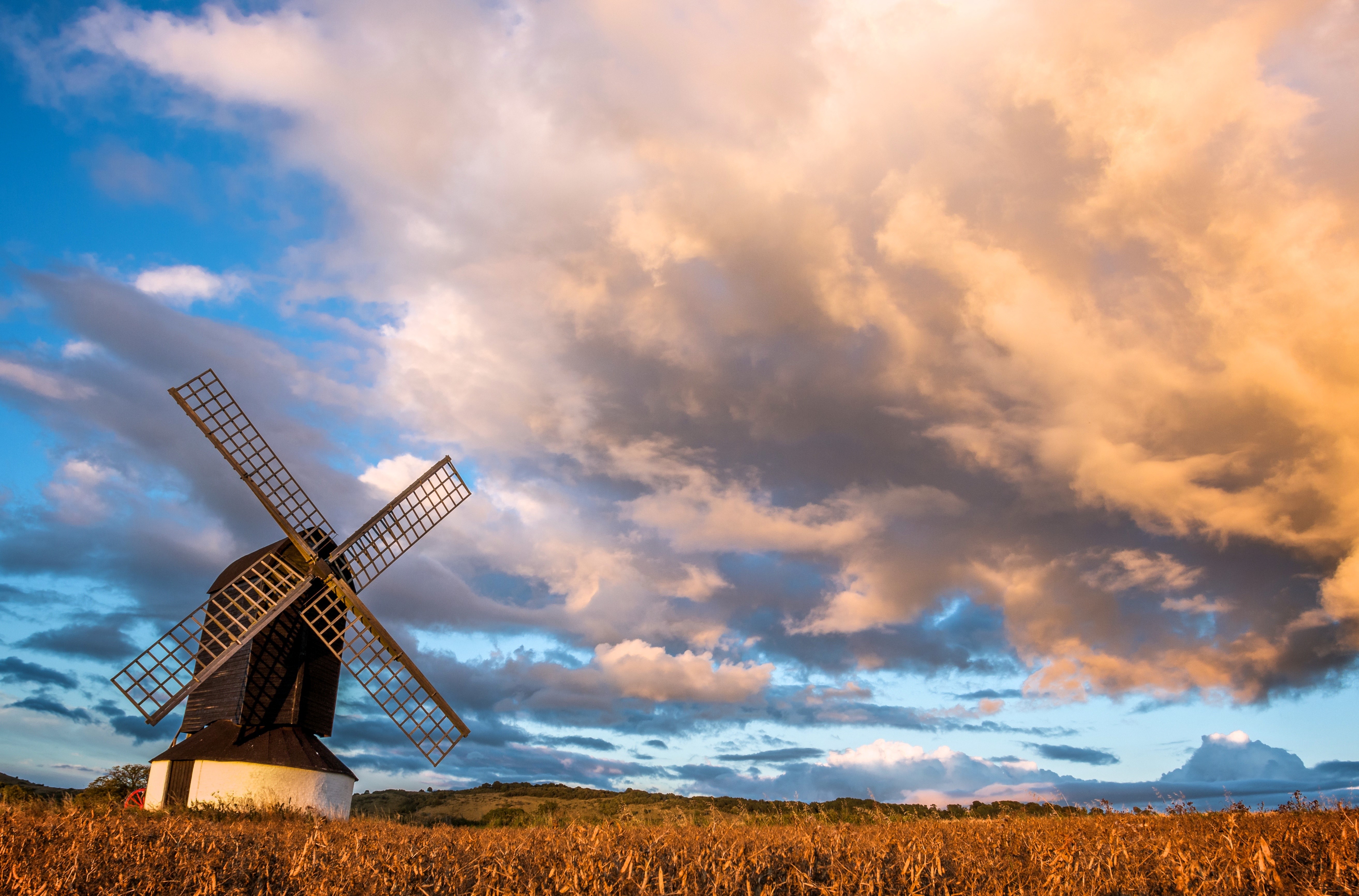 Windmill in a field under a dramatic sky HD Wallpaper