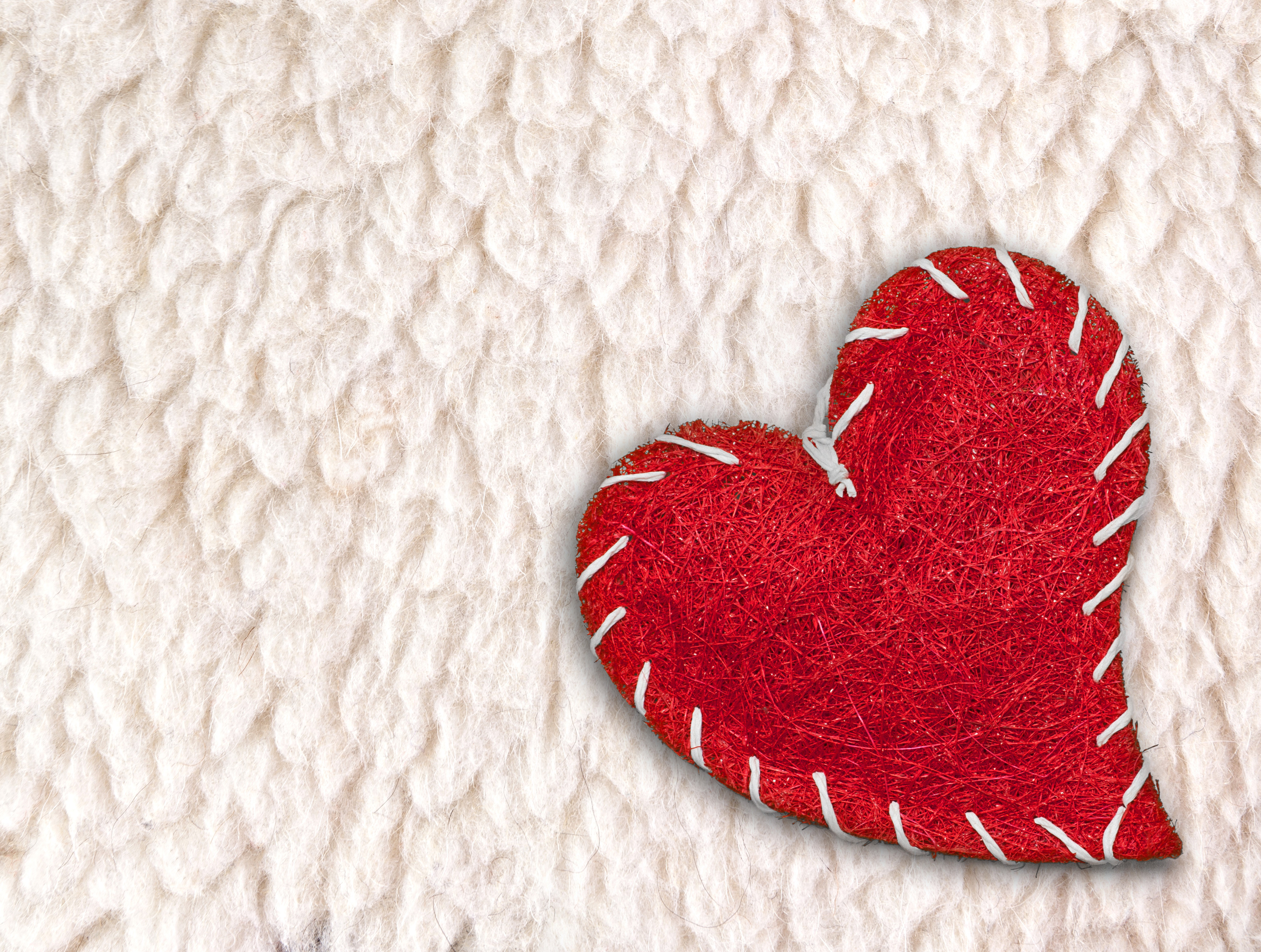 Red stitched heart on textured background HD Wallpaper
