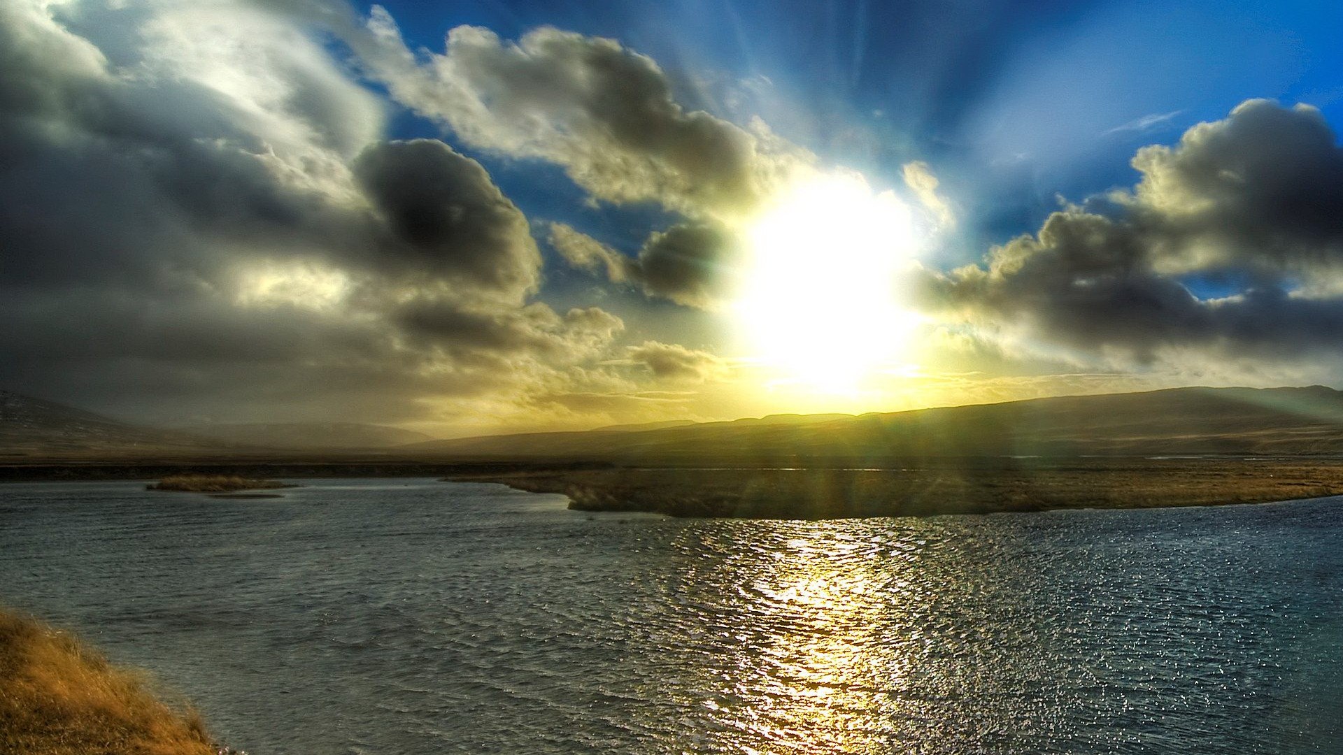 Sunbeams through clouds over a body of water HD Wallpaper