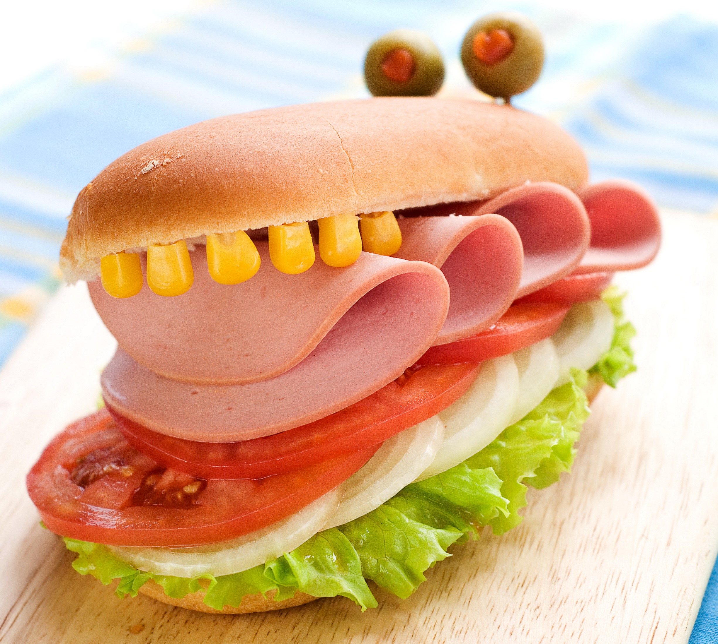 Monster sandwich with ham, vegetables, and corn teeth HD Wallpaper