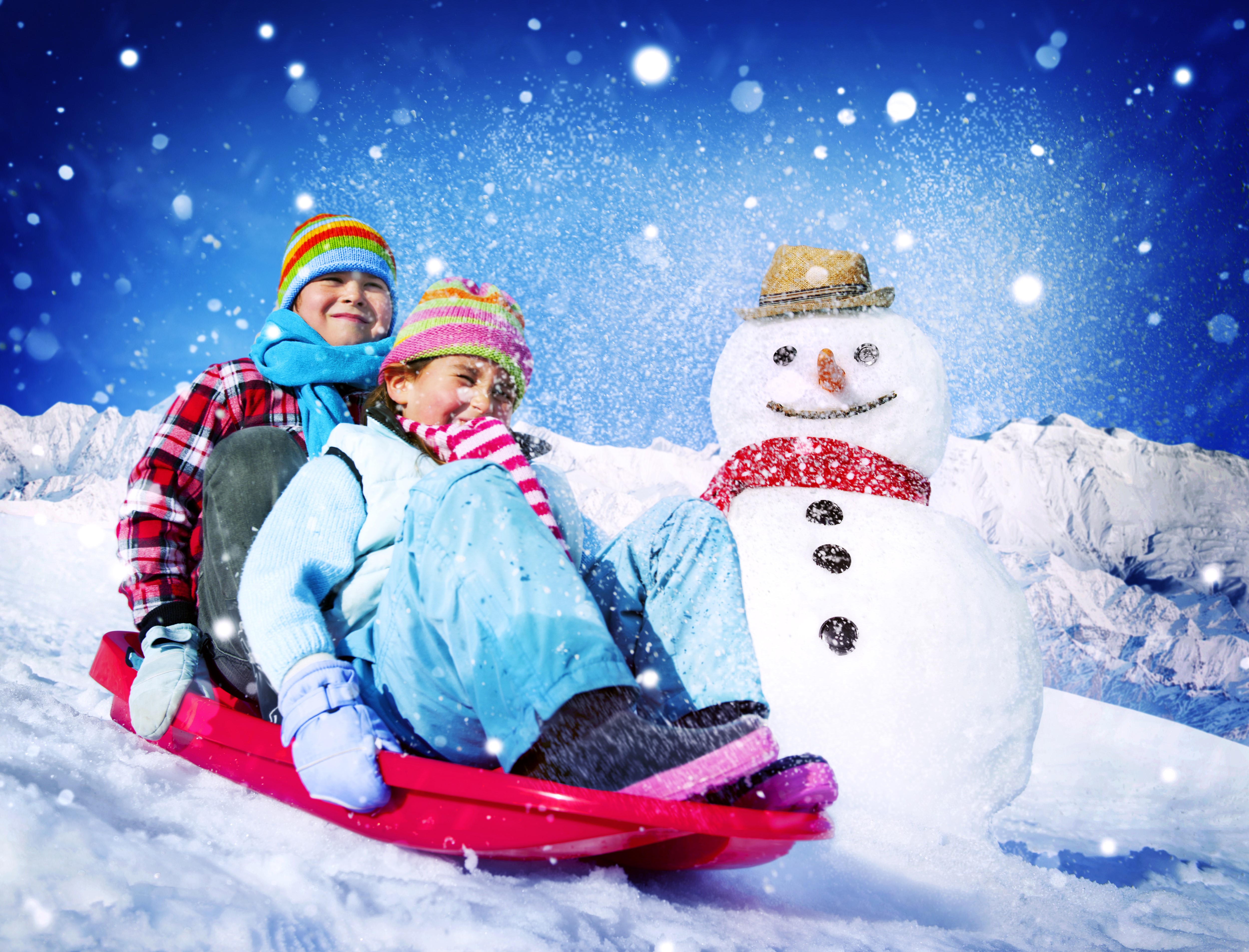 Children sledding with a snowman HD Wallpaper