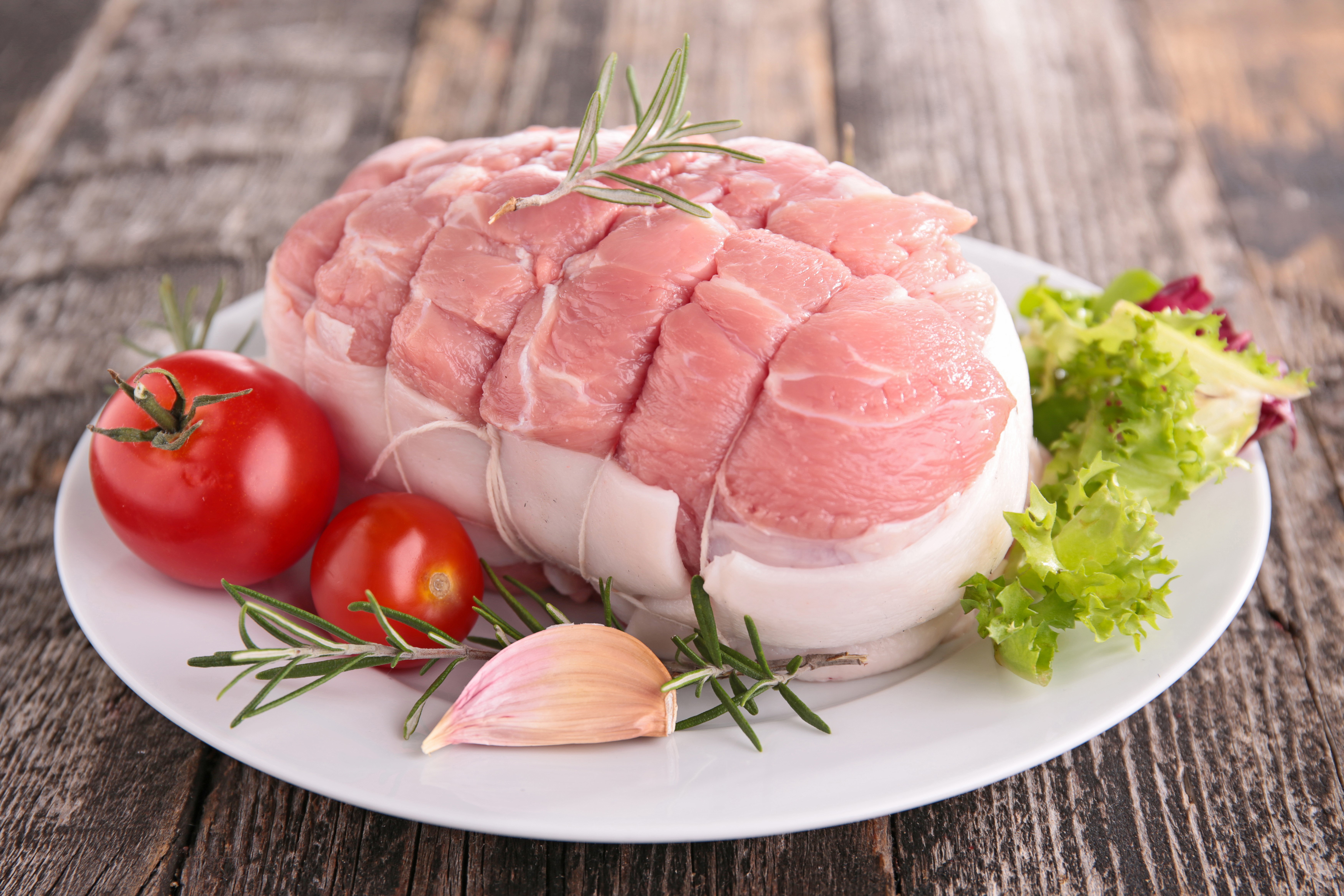 Raw meat roast with tomatoes, garlic, and rosemary HD Wallpaper