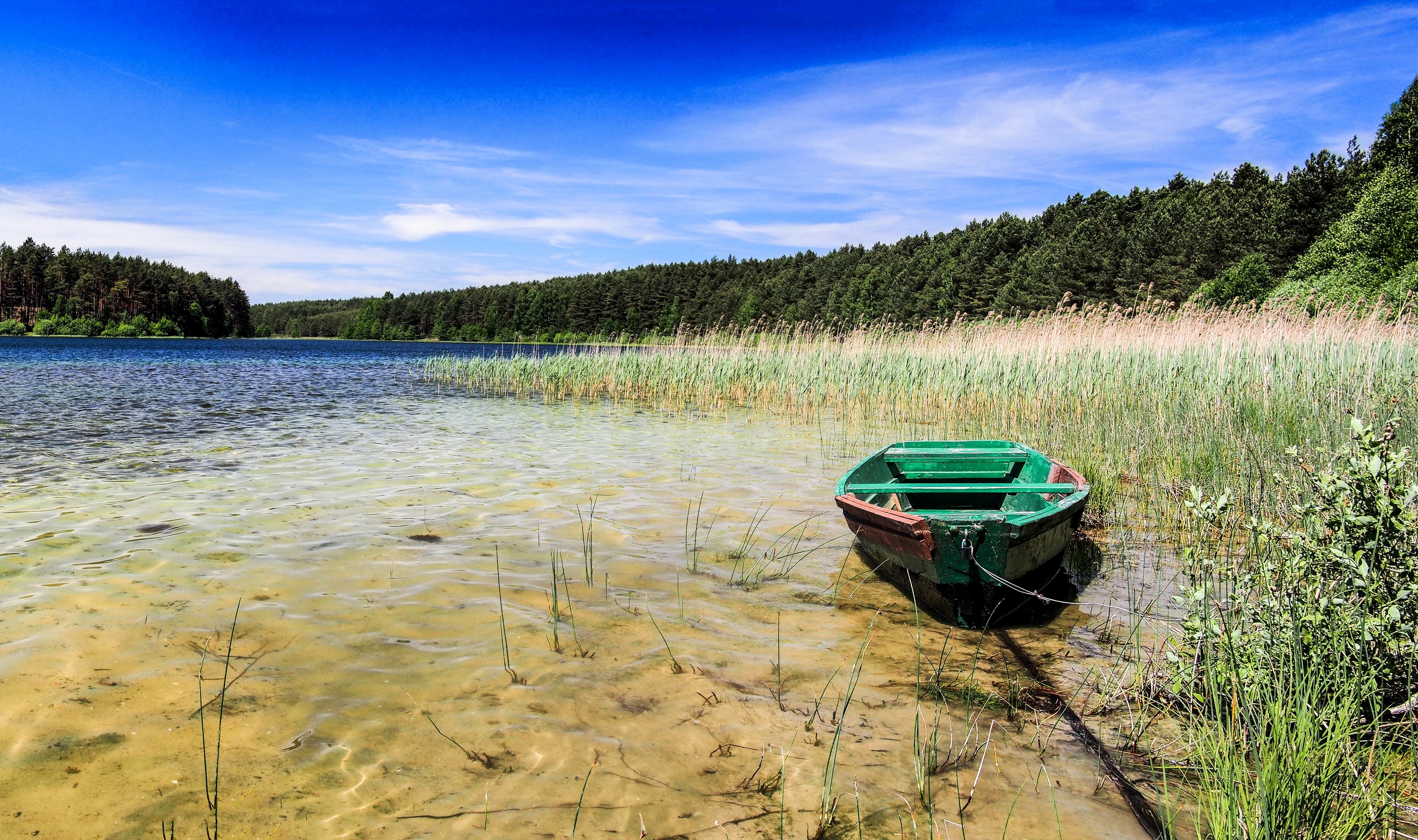 Green boat on the shore of Kotel Lake, Poland HD Wallpaper