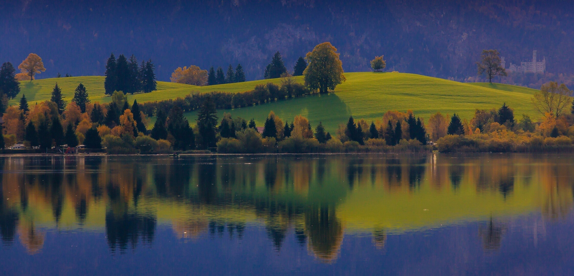 Lake reflection of autumn trees and Bavarian castle HD Wallpaper