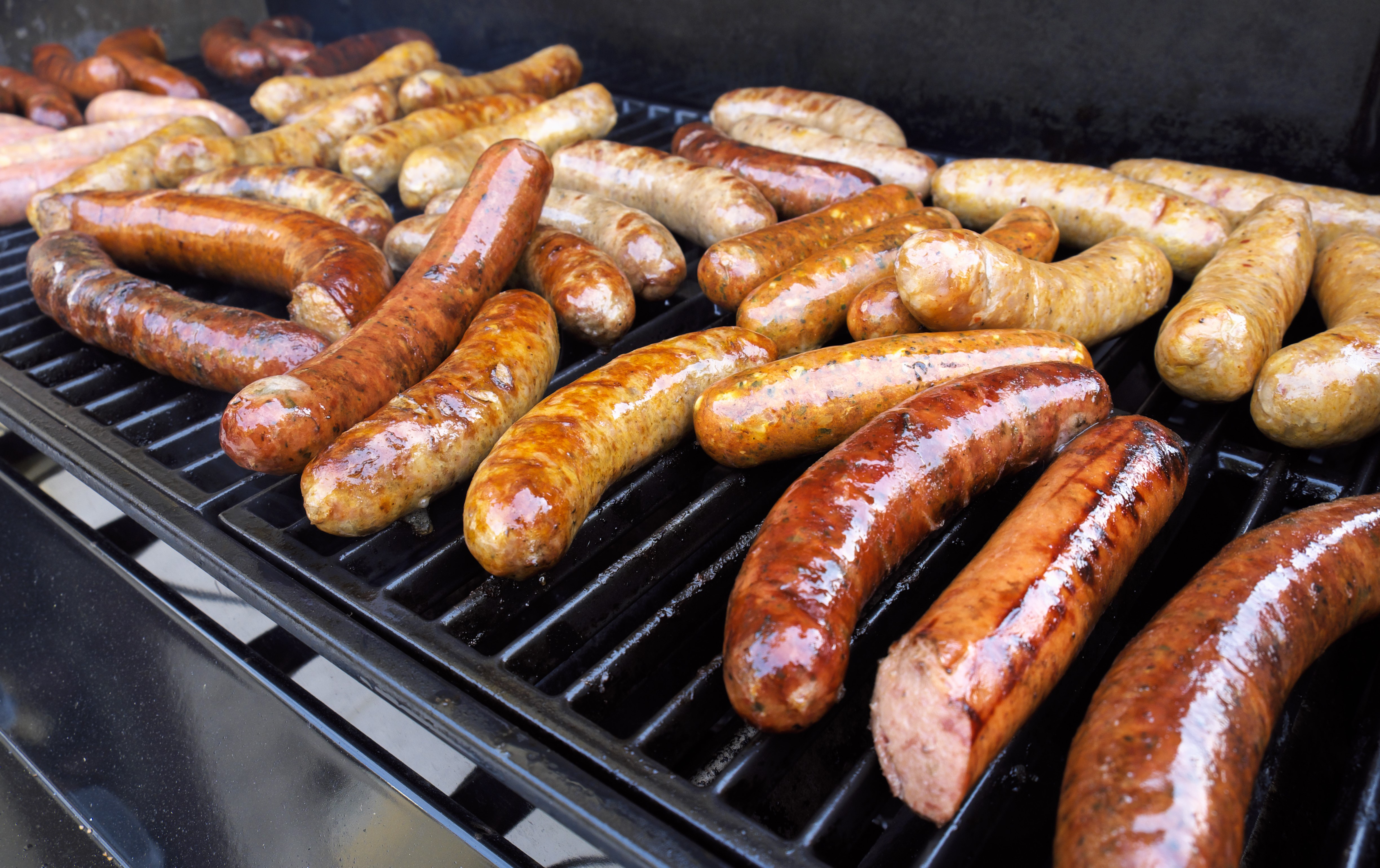Sausages grilling on a barbecue HD Wallpaper