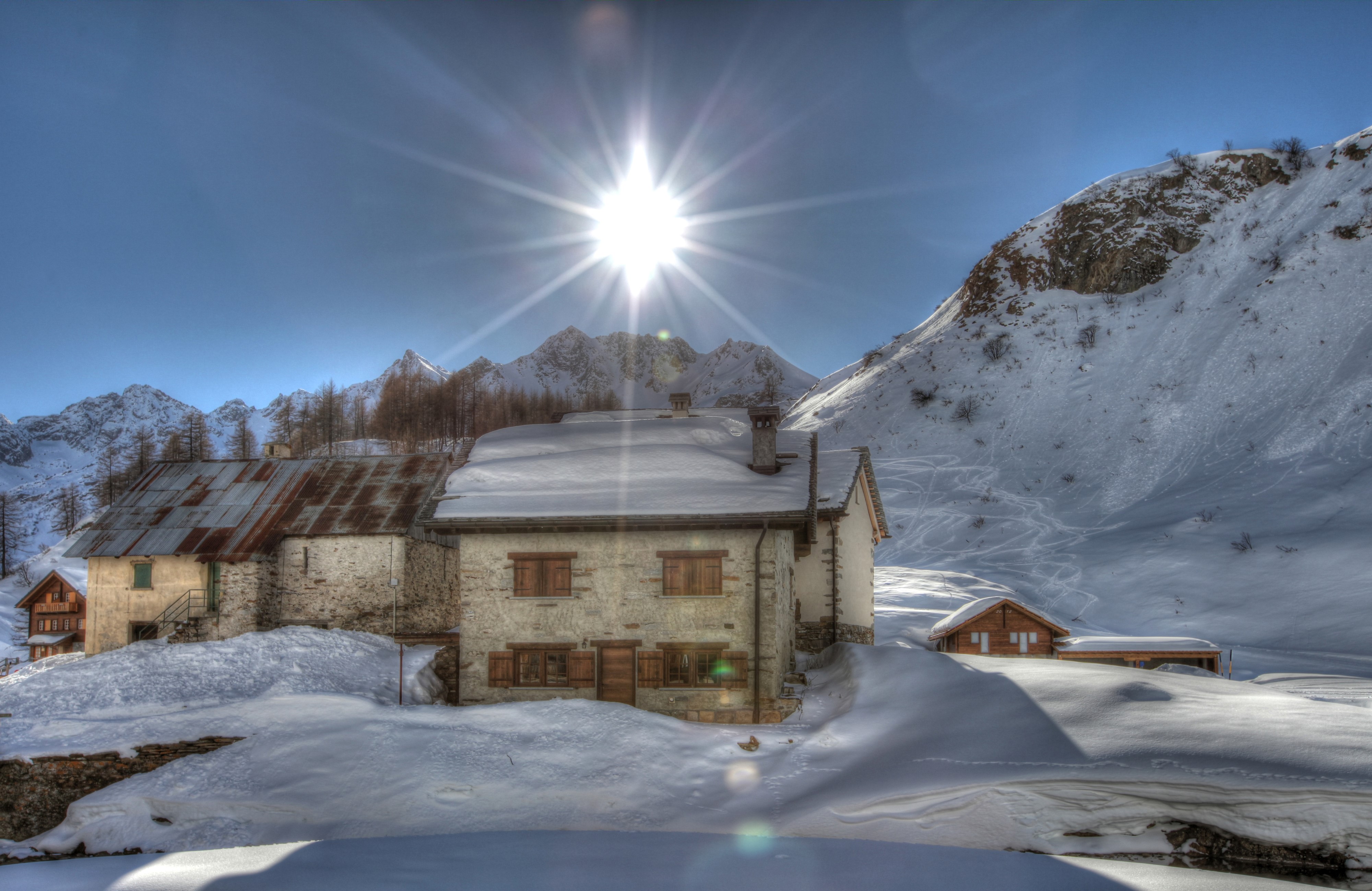 4K Winter Scene in the Italian Alps with Houses and Sun Rays HD Wallpaper