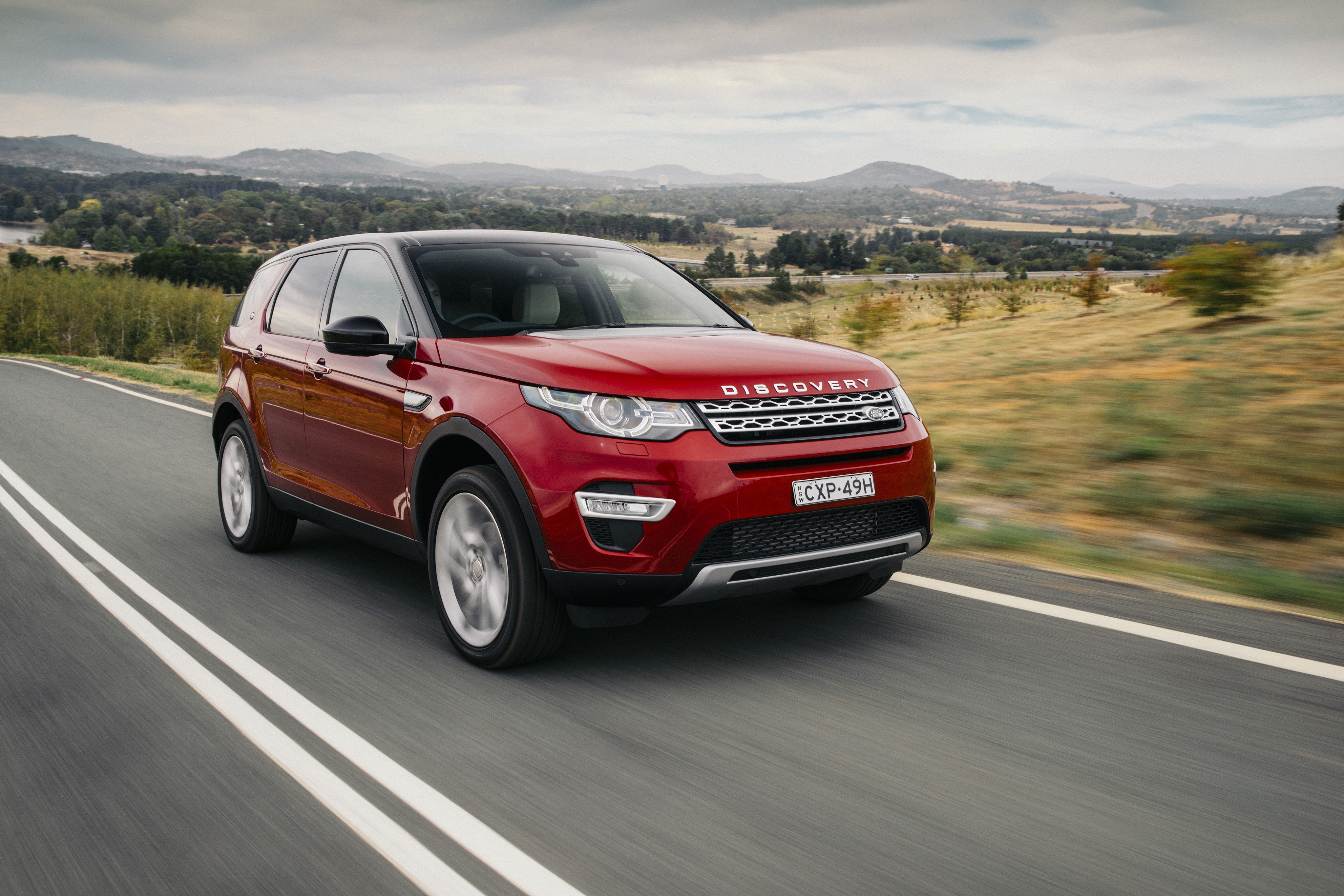 Red 2015 Land Rover Discovery Sport driving HD Wallpaper