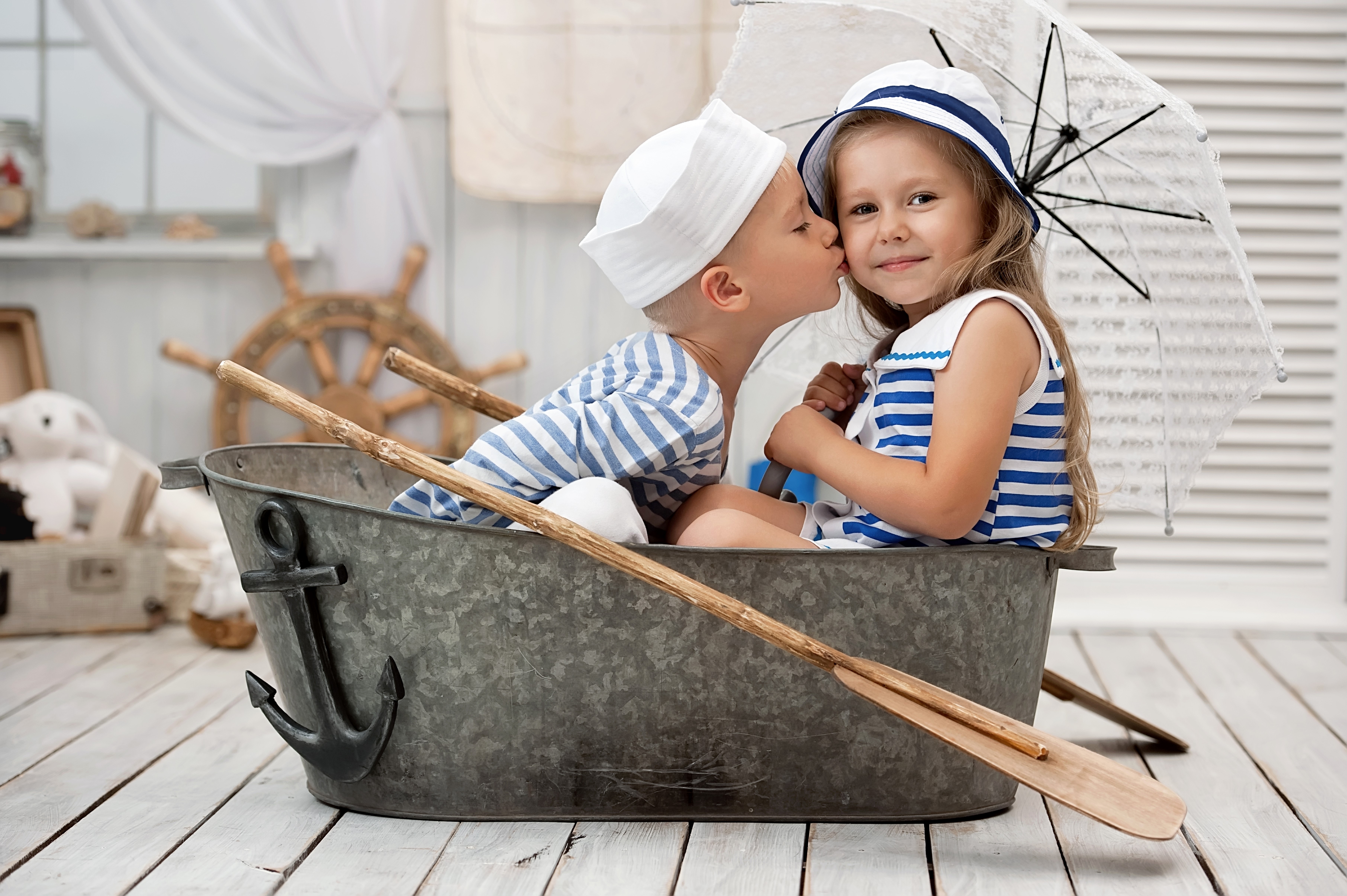 Boy kissing girl in a boat with umbrella HD Wallpaper