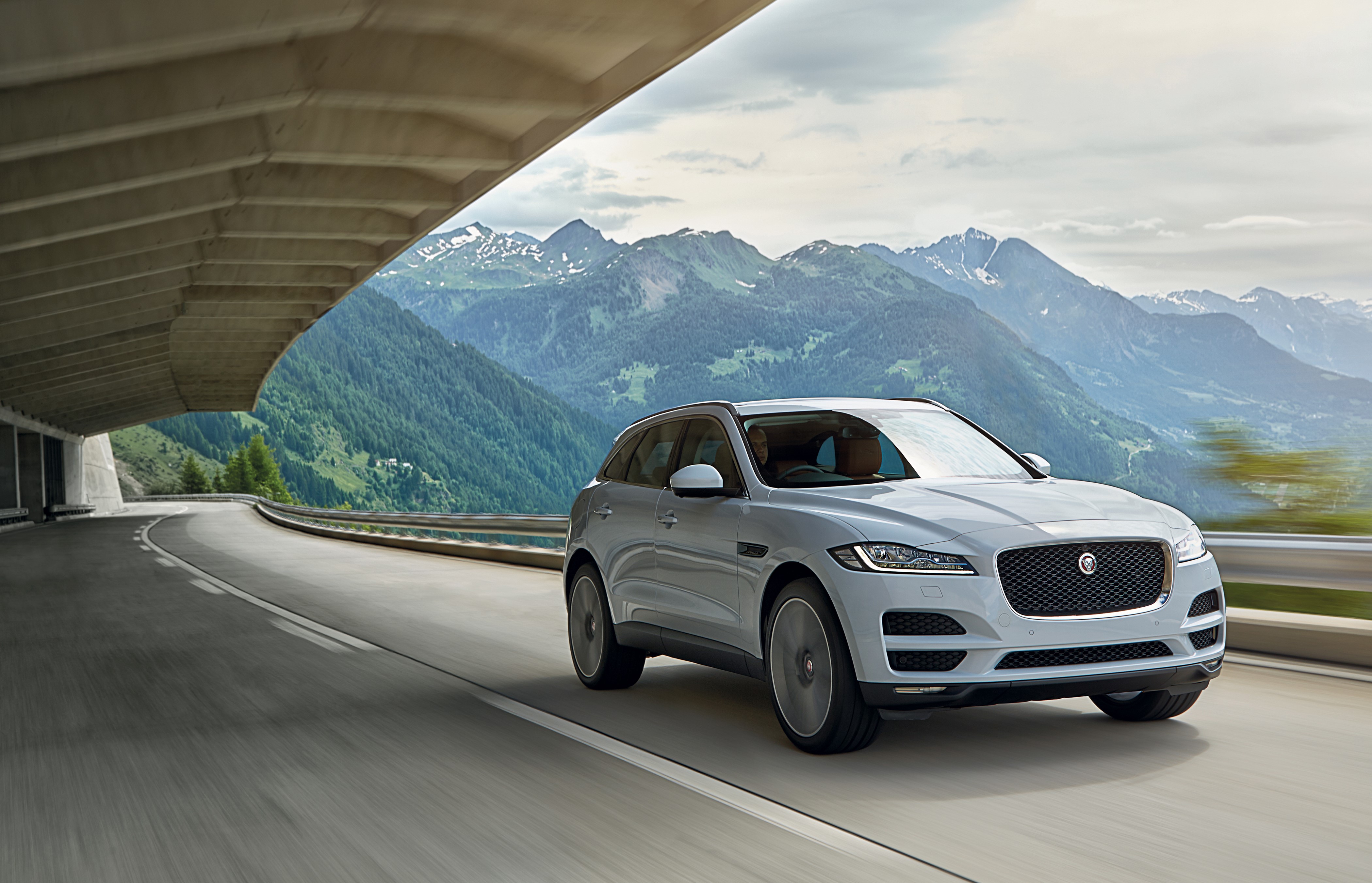 White Jaguar F-Pace driving on mountain road HD Wallpaper