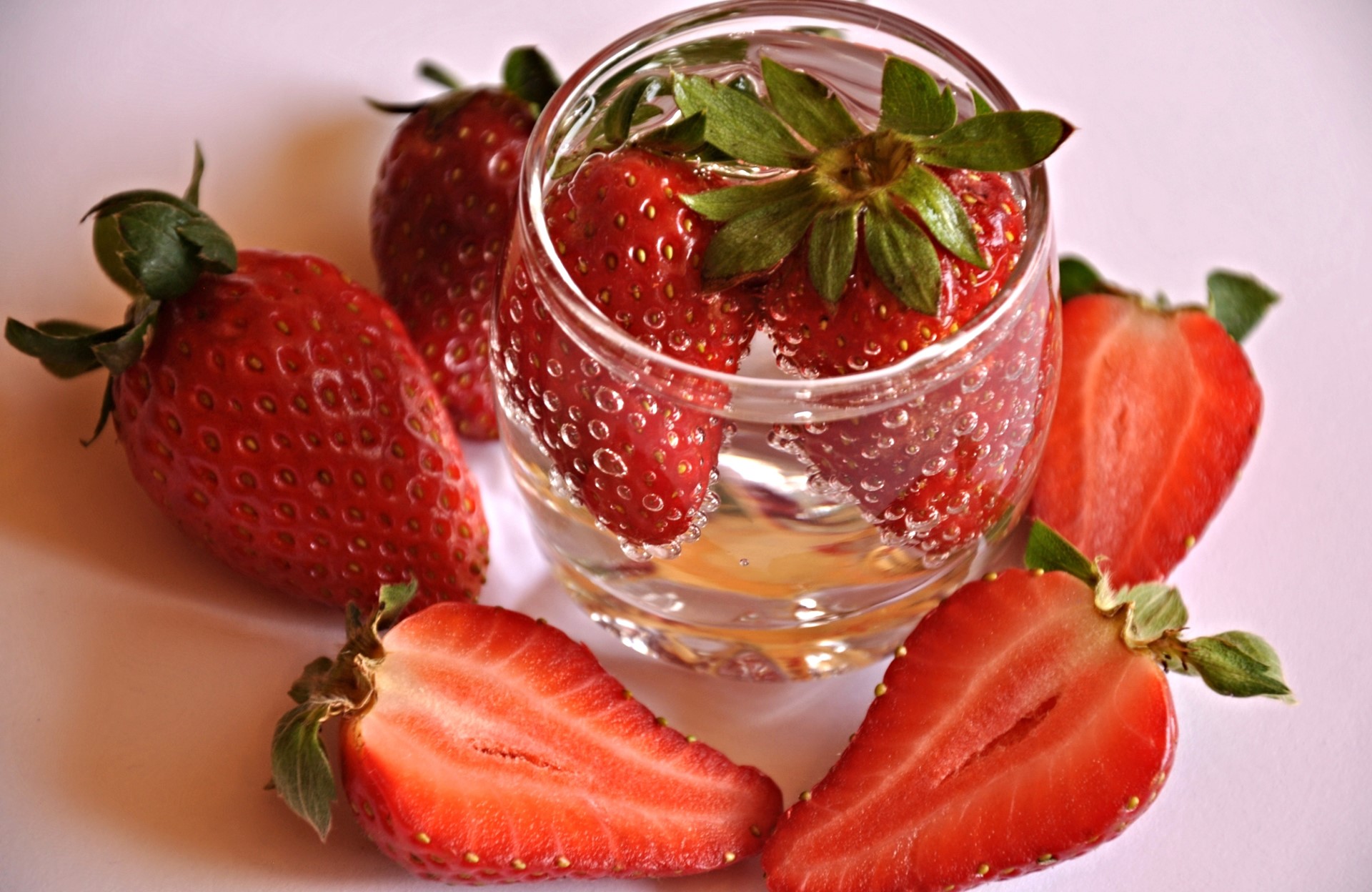 Strawberries in a glass with sliced strawberries HD Wallpaper
