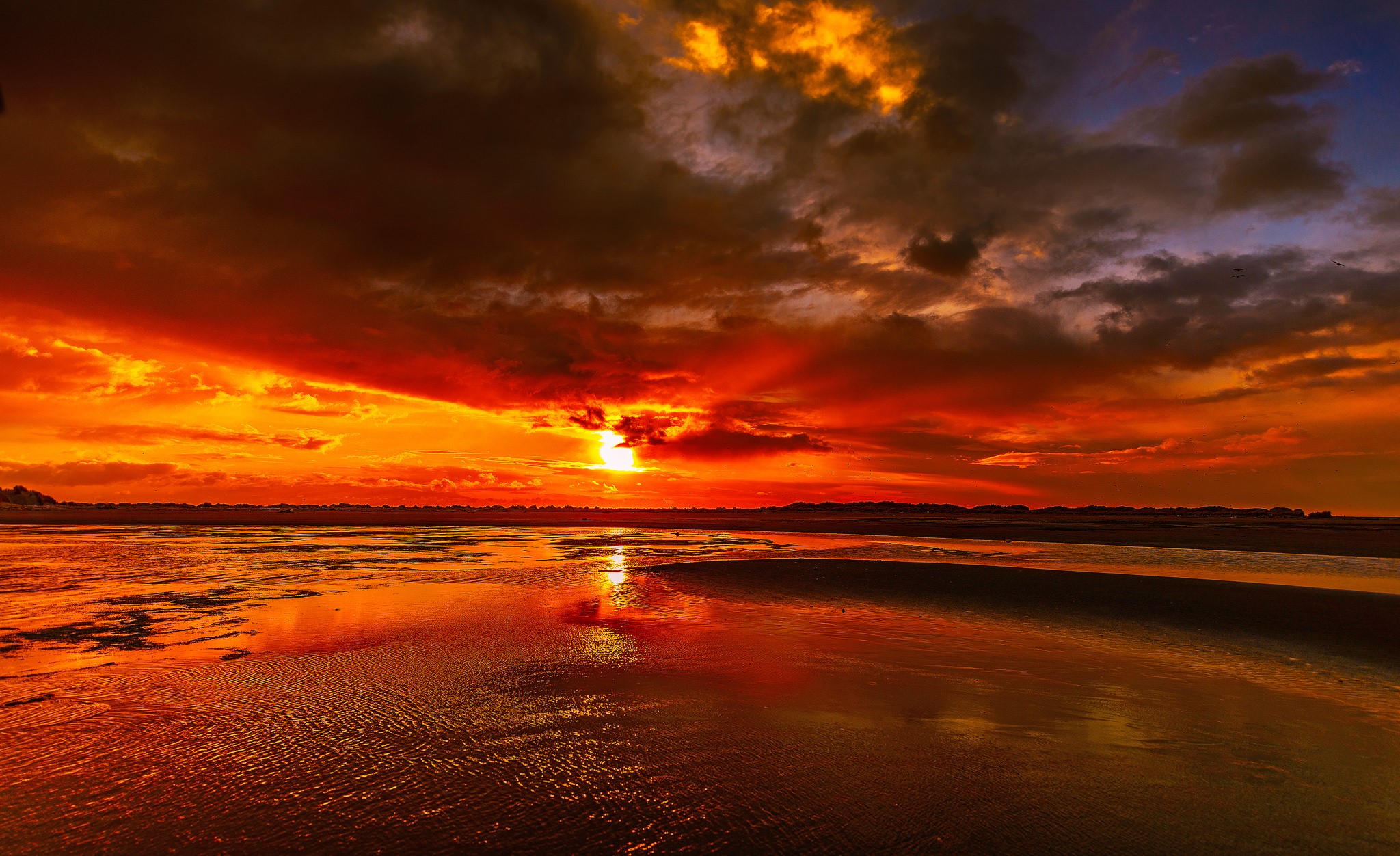 Dramatic sunset over a wet beach with reflections HD Wallpaper