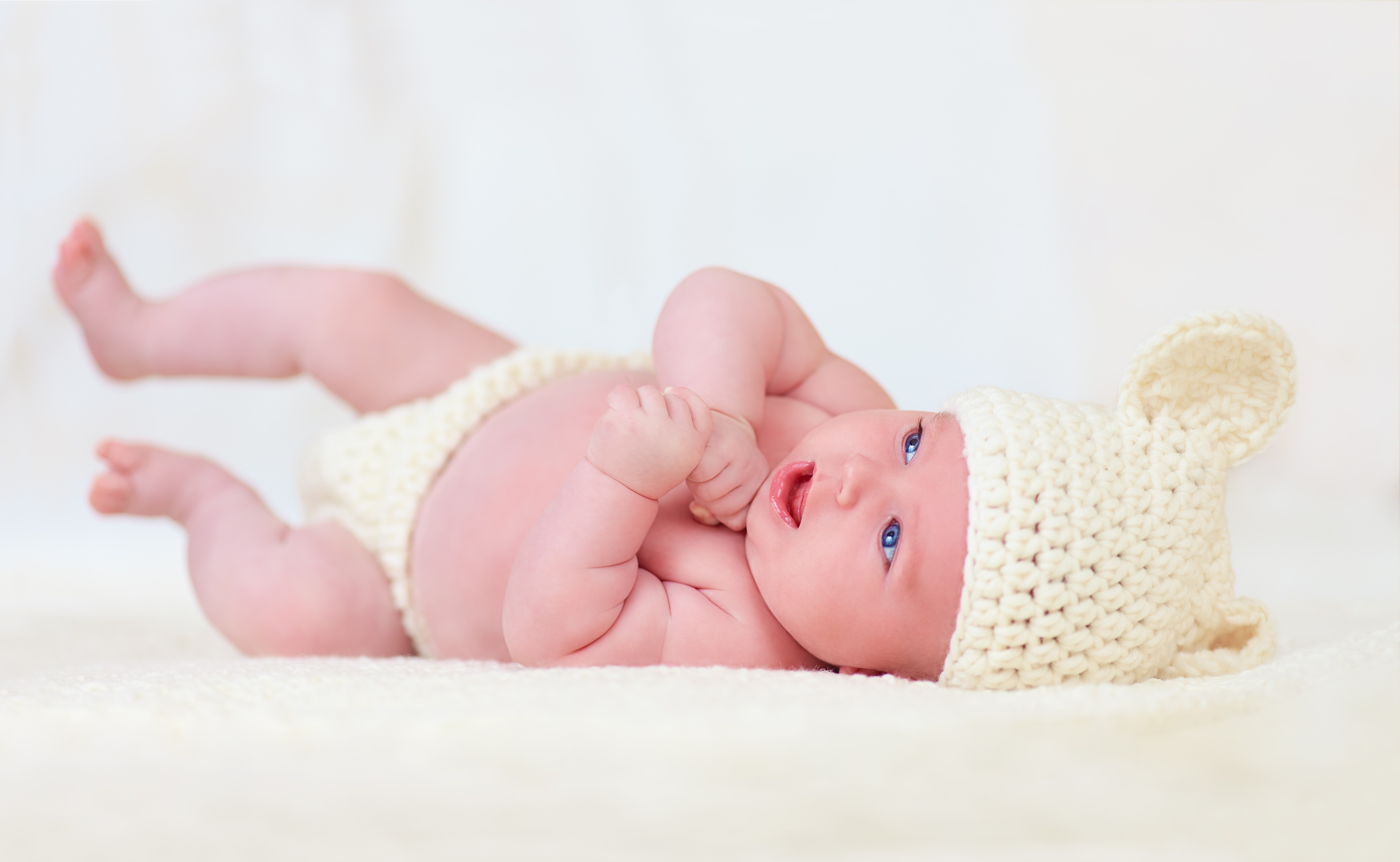 Infant wearing a knitted hat and diaper HD Wallpaper