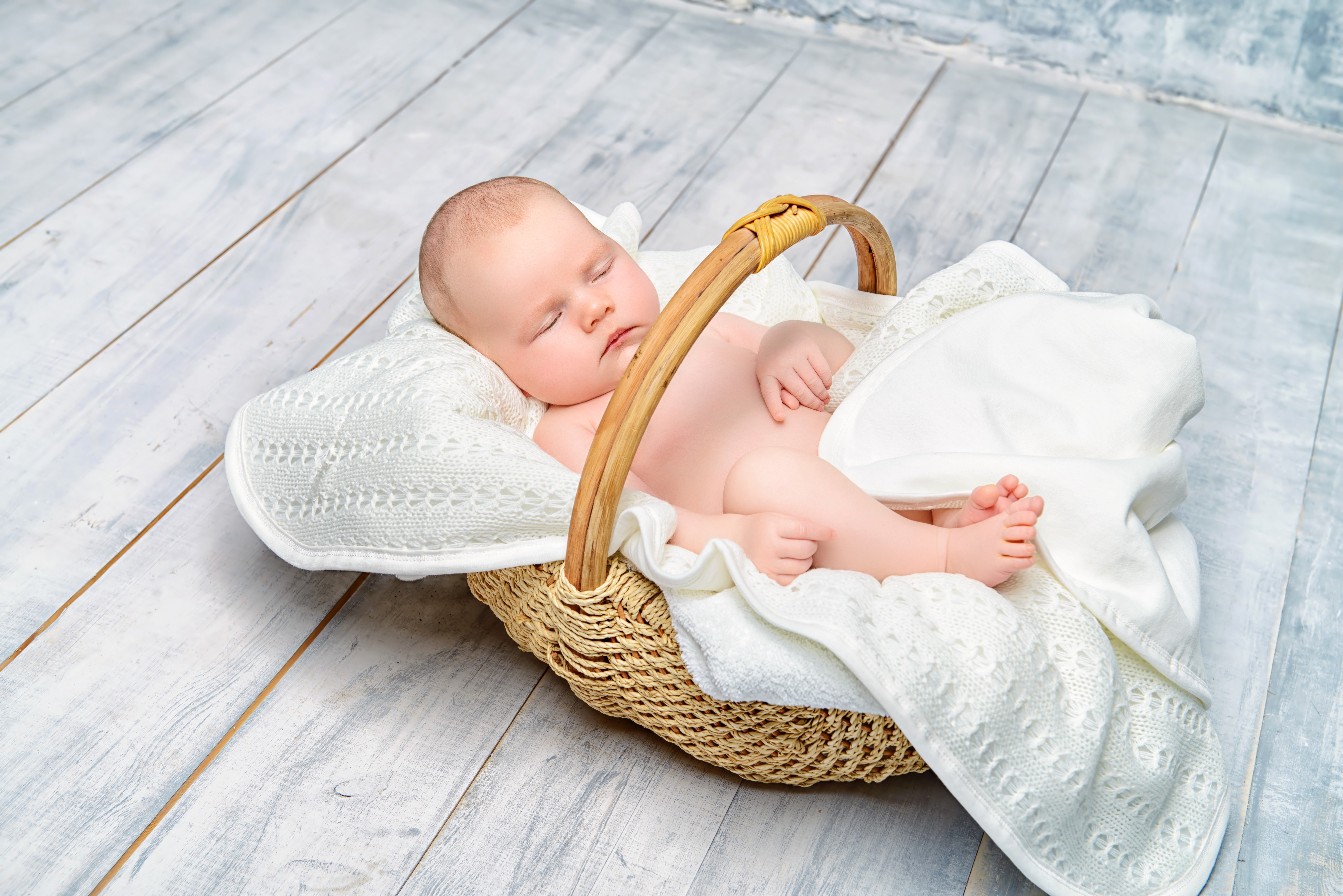 Infant sleeping in a wicker basket HD Wallpaper