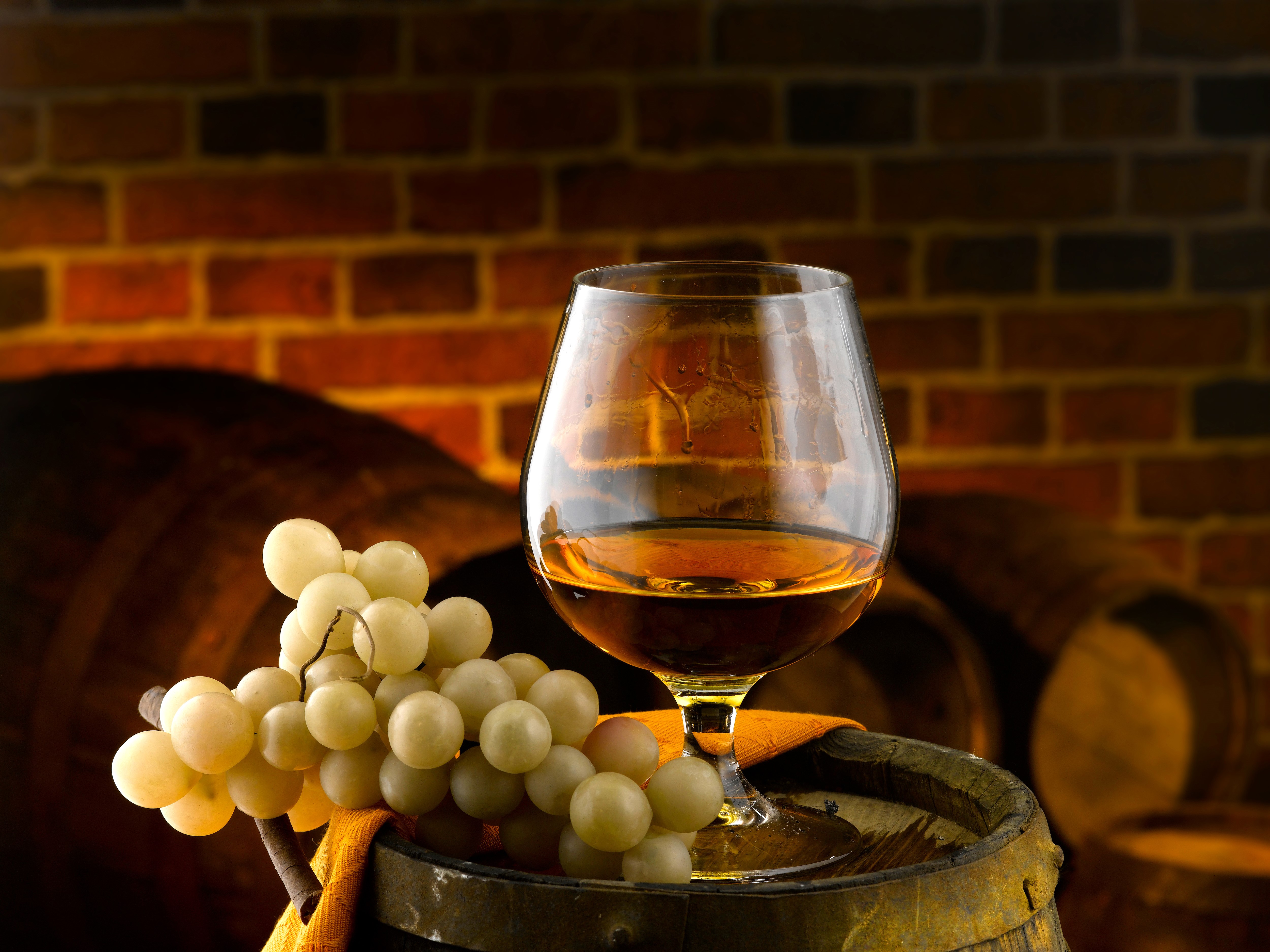 Cognac glass with grapes on a barrel HD Wallpaper