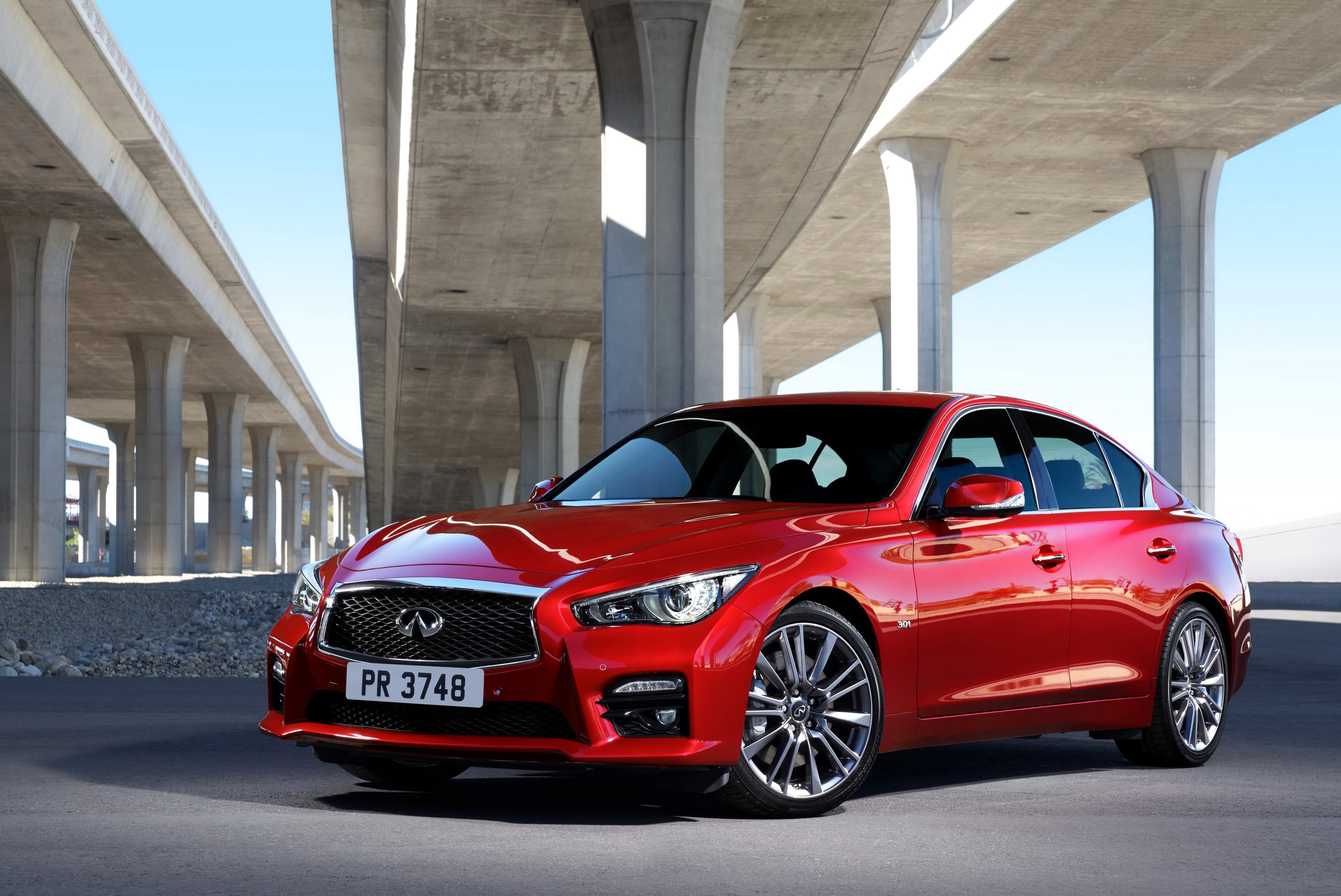 Red 2016 Infiniti Q50S sedan under concrete overpass HD Wallpaper