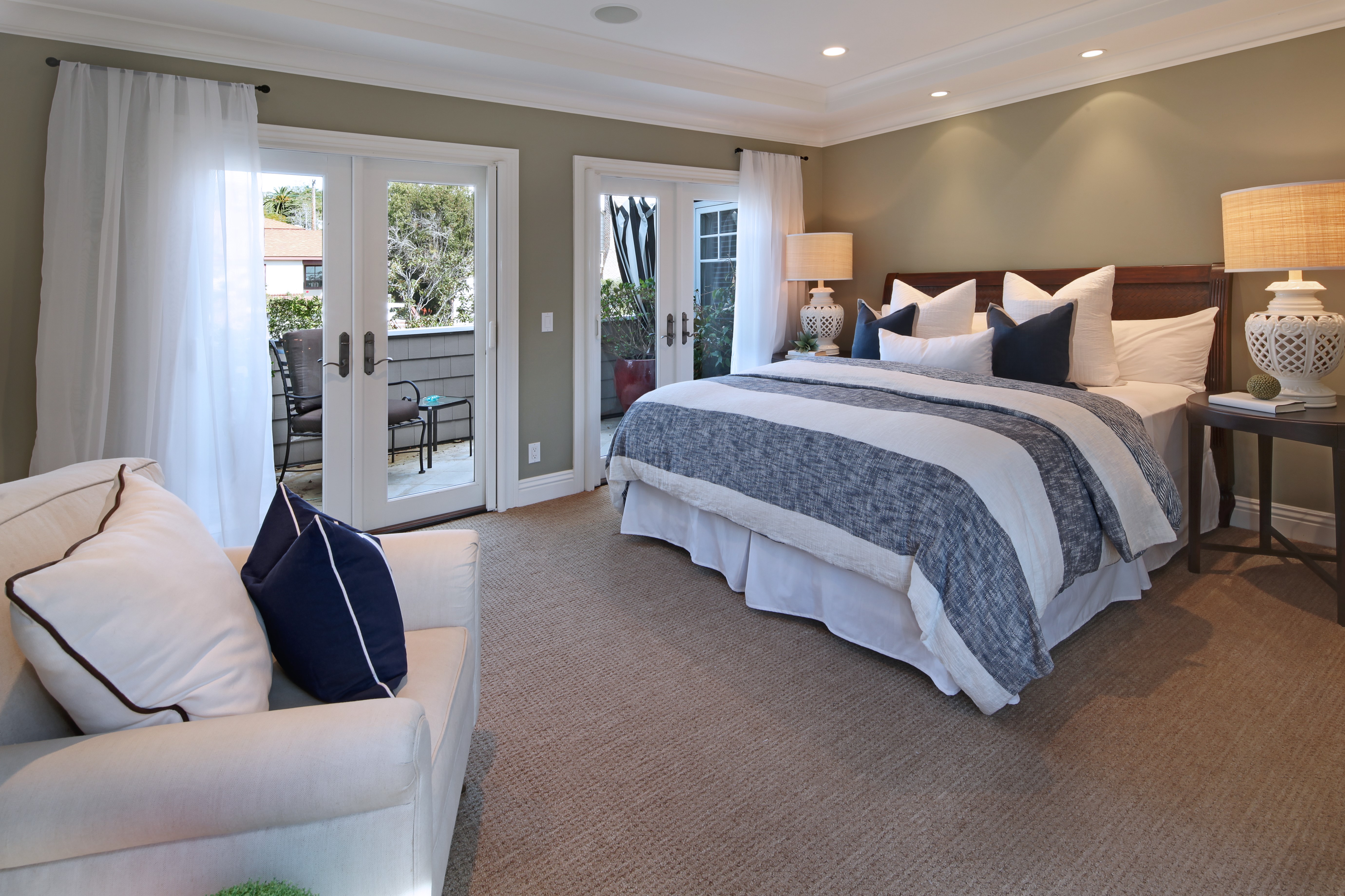 Bedroom with bed, armchair, and balcony doors HD Wallpaper