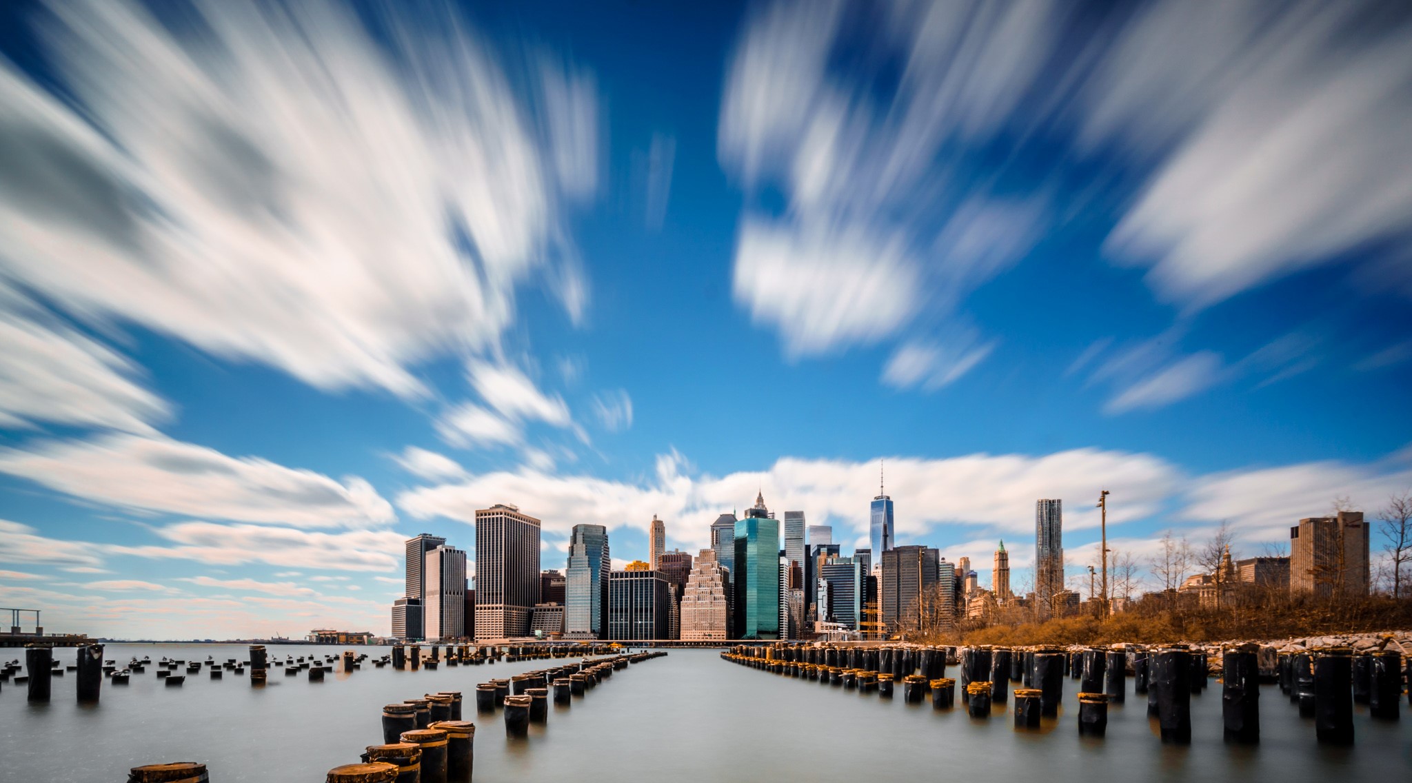 New York City skyline with blurred clouds over water HD Wallpaper