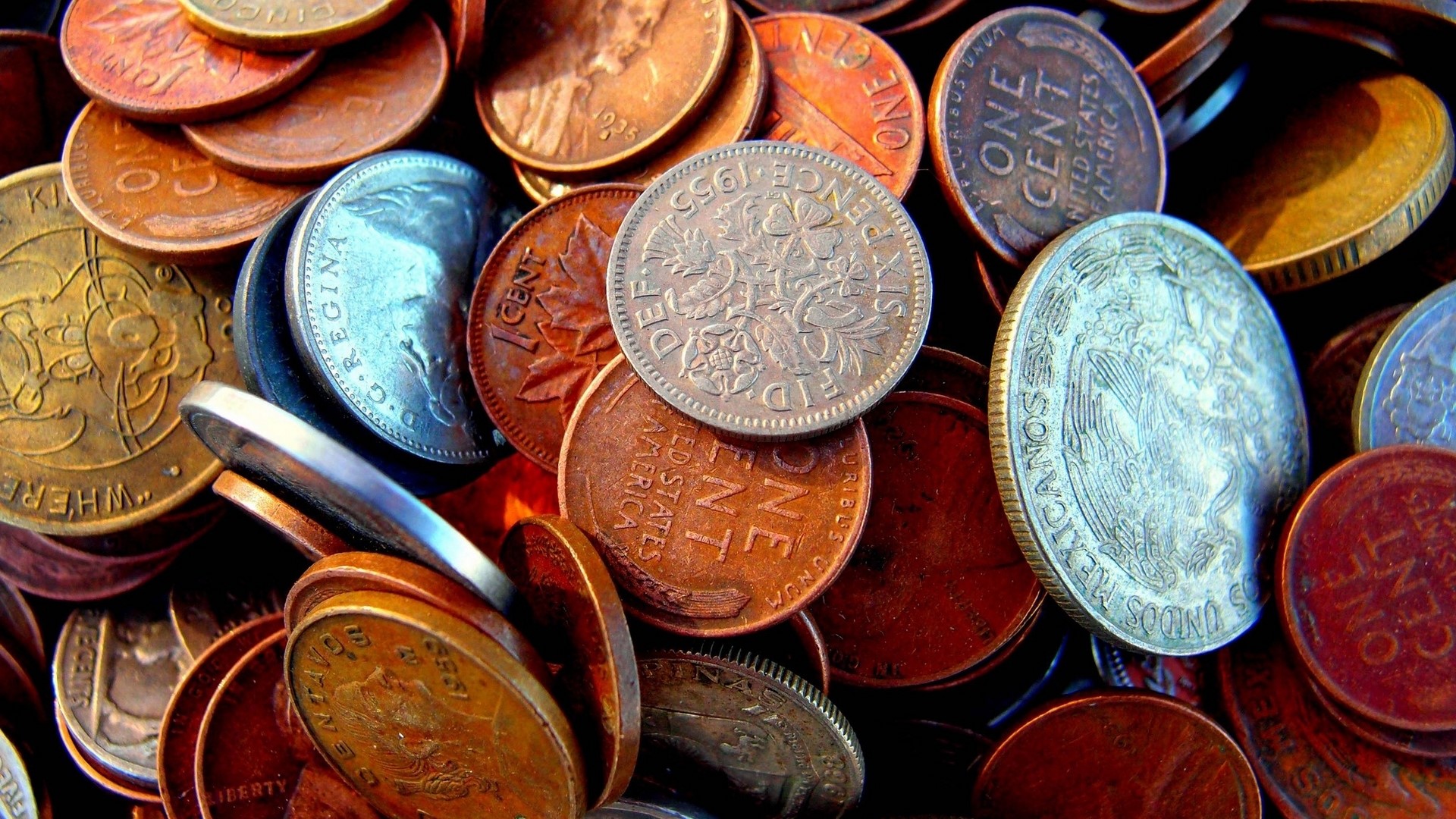A close-up of a pile of various coins HD Wallpaper