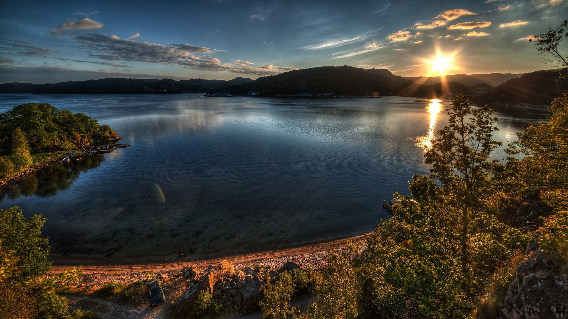Sunset over a calm lake with forested hills HD Wallpaper