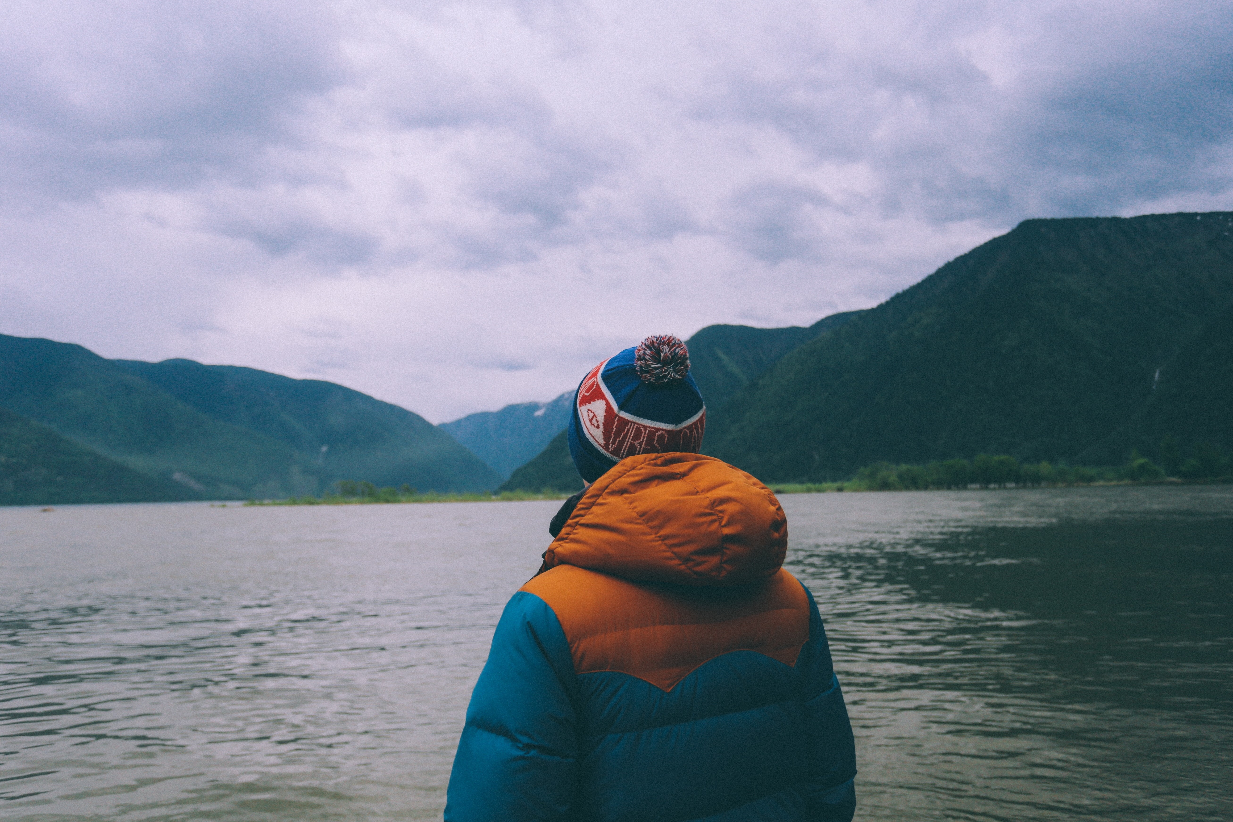 Person in Jacket and Winter Hat by Mountains and Lake HD Wallpaper
