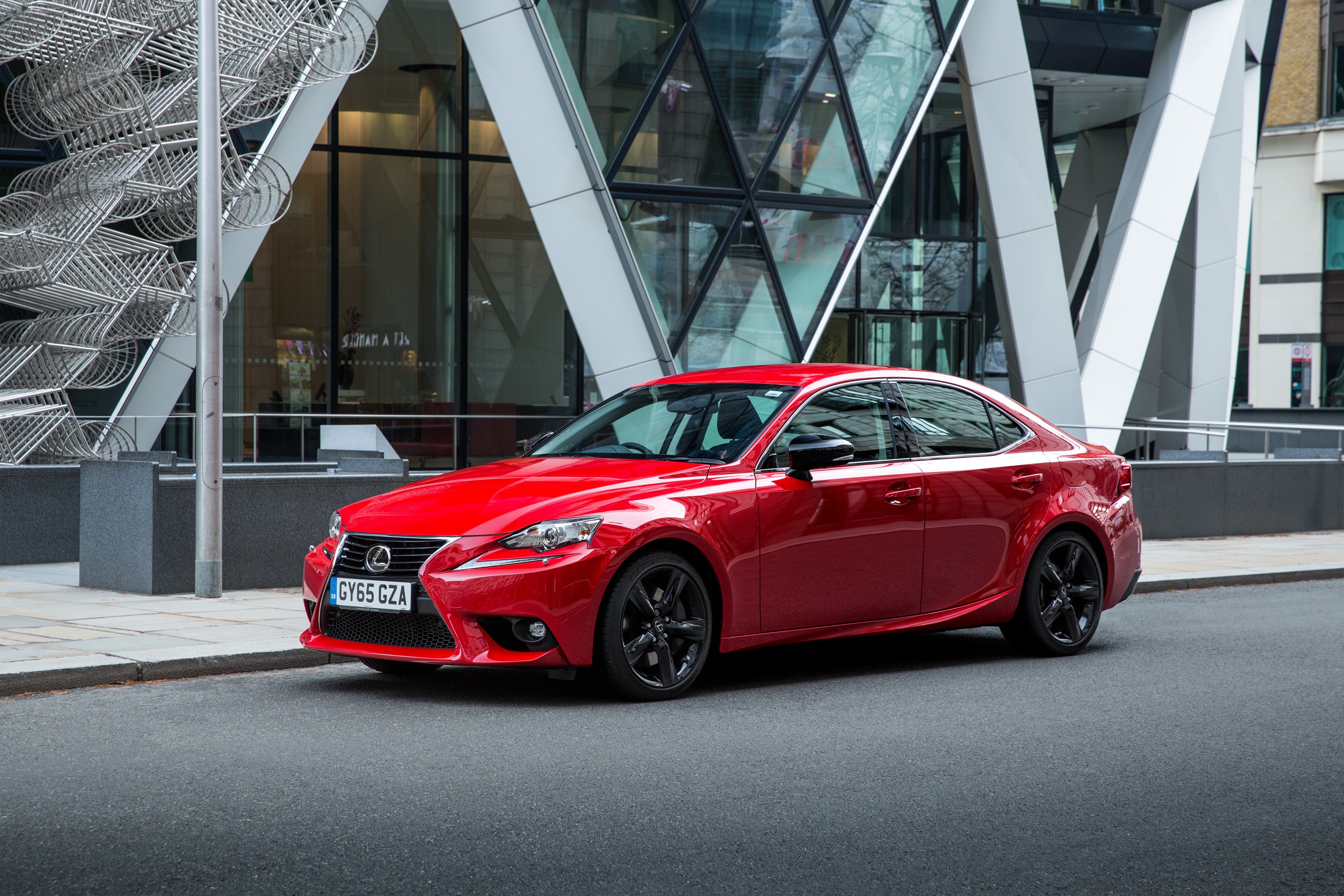 Red Lexus IS parked in front of a modern building HD Wallpaper