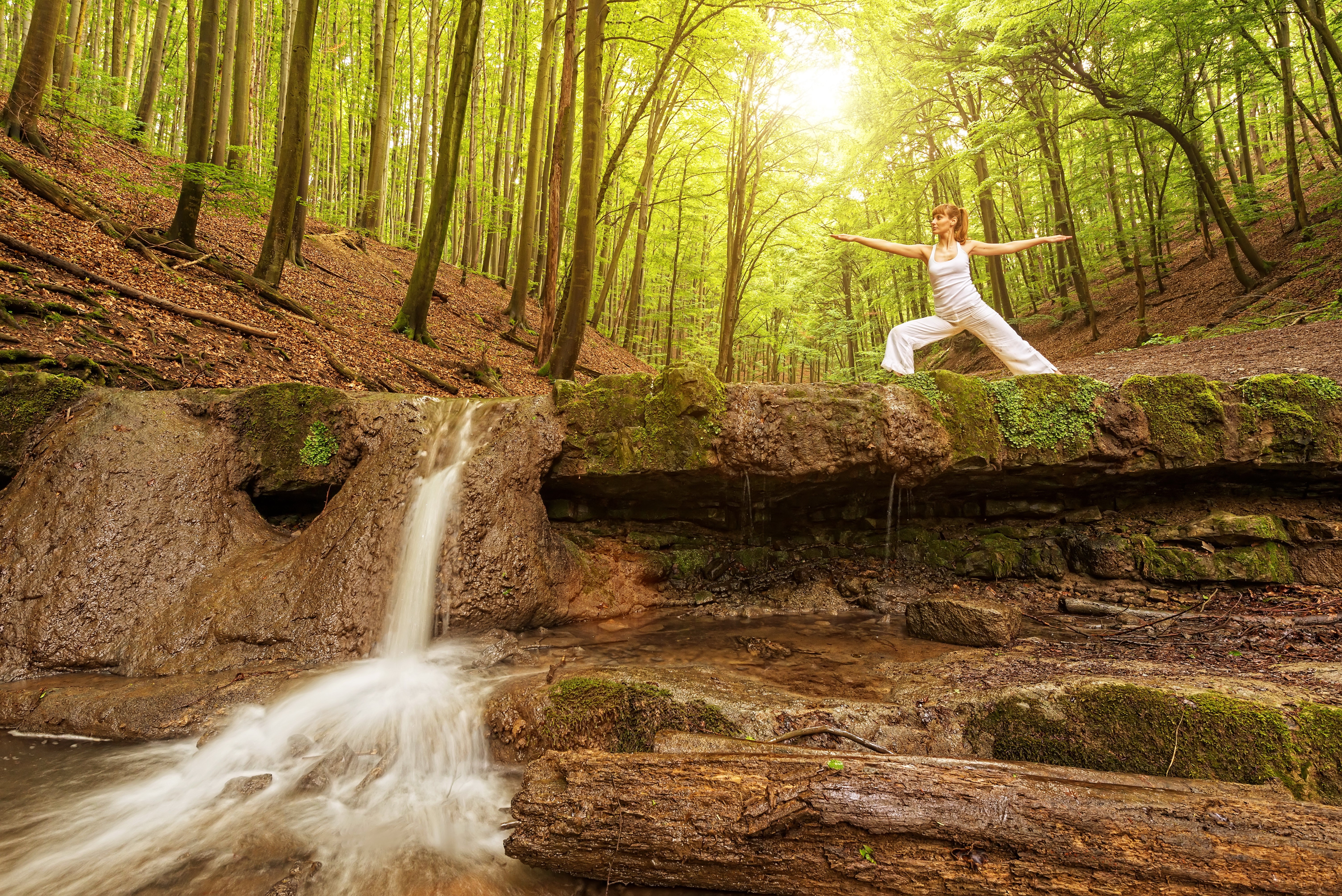 Woman practicing yoga by a waterfall in a forest HD Wallpaper