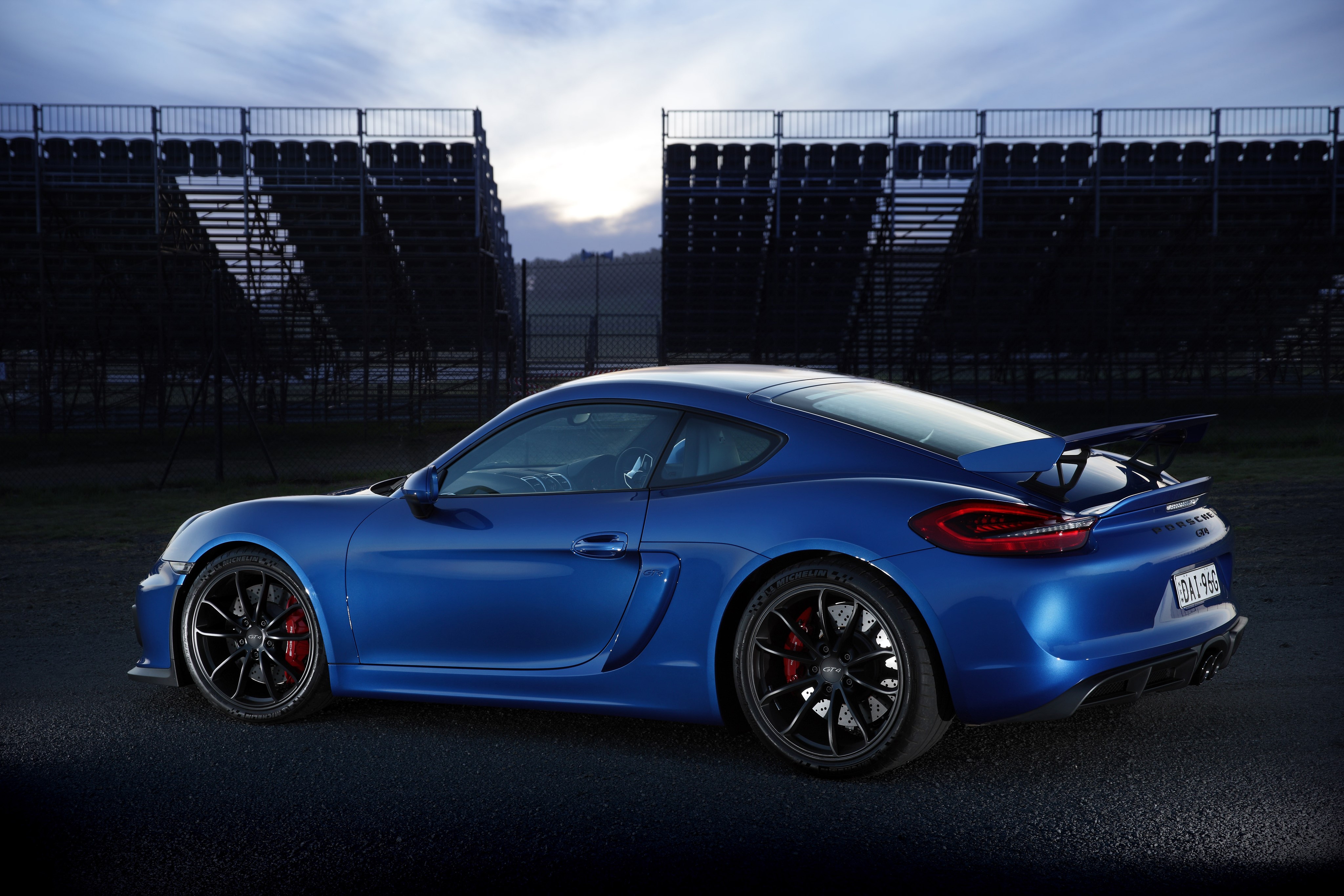 Blue Porsche Cayman GT4 on a Racetrack HD Wallpaper