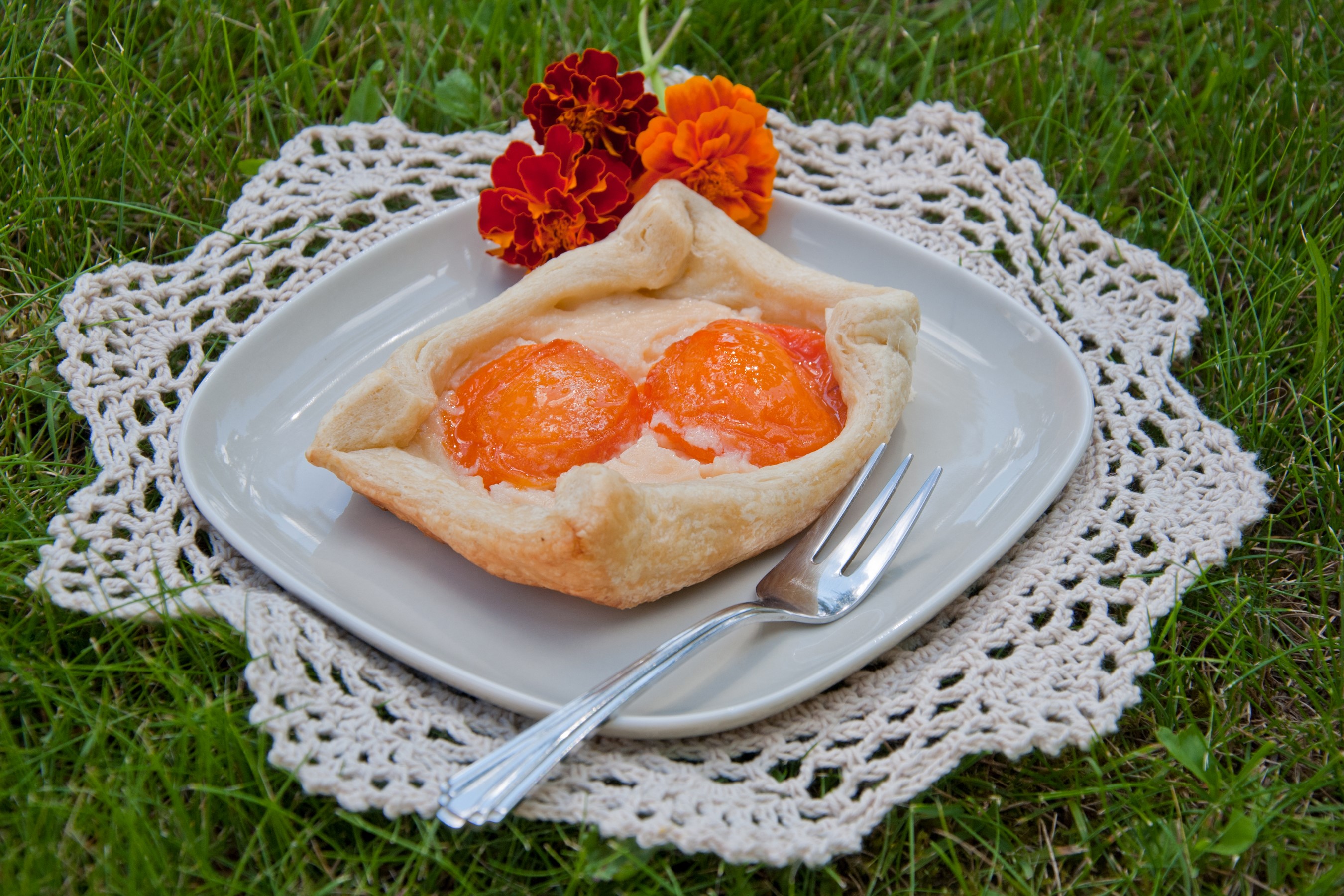 Apricot pastry on a plate with flowers and fork HD Wallpaper