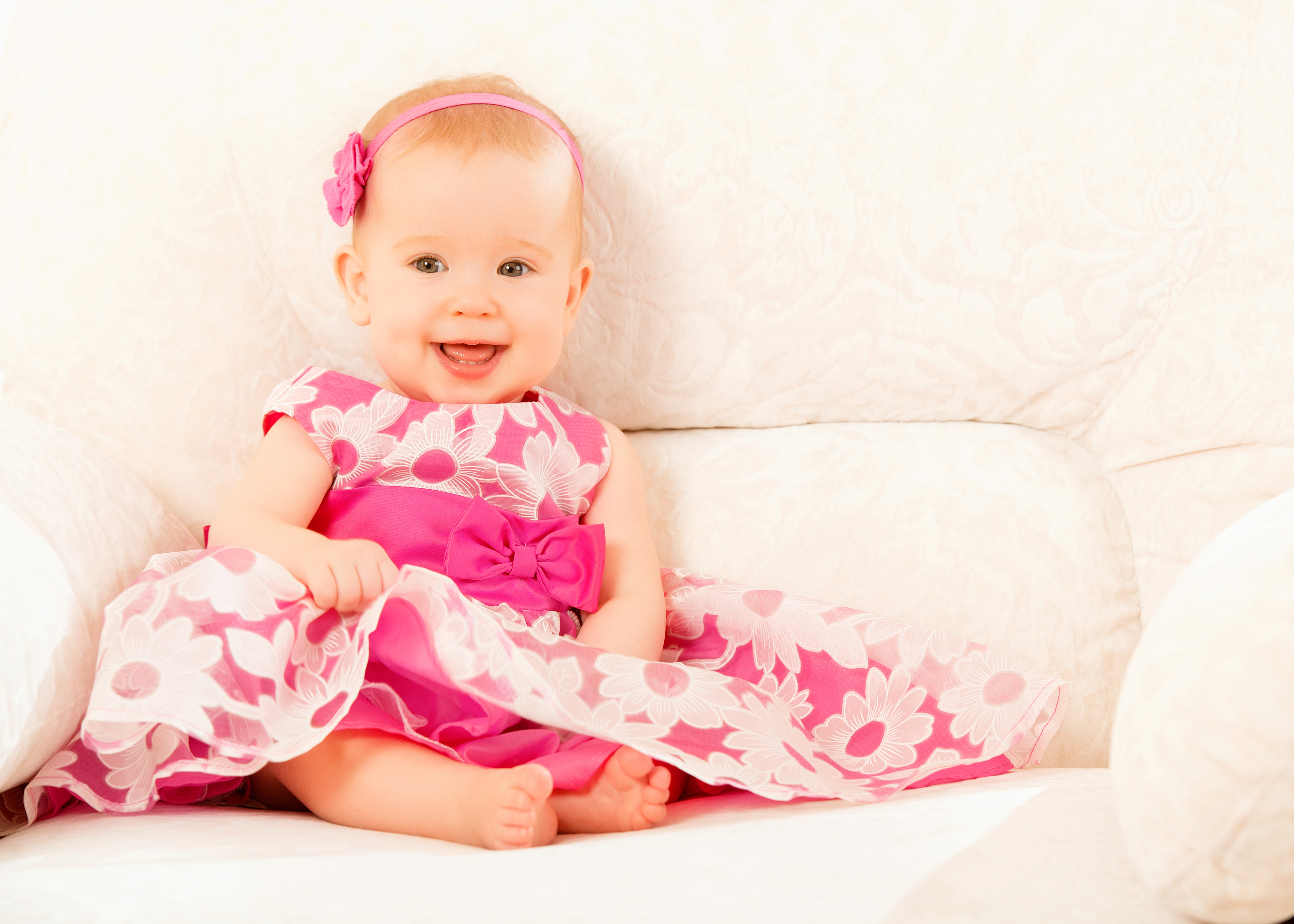 Baby girl in a pink floral dress smiling HD Wallpaper