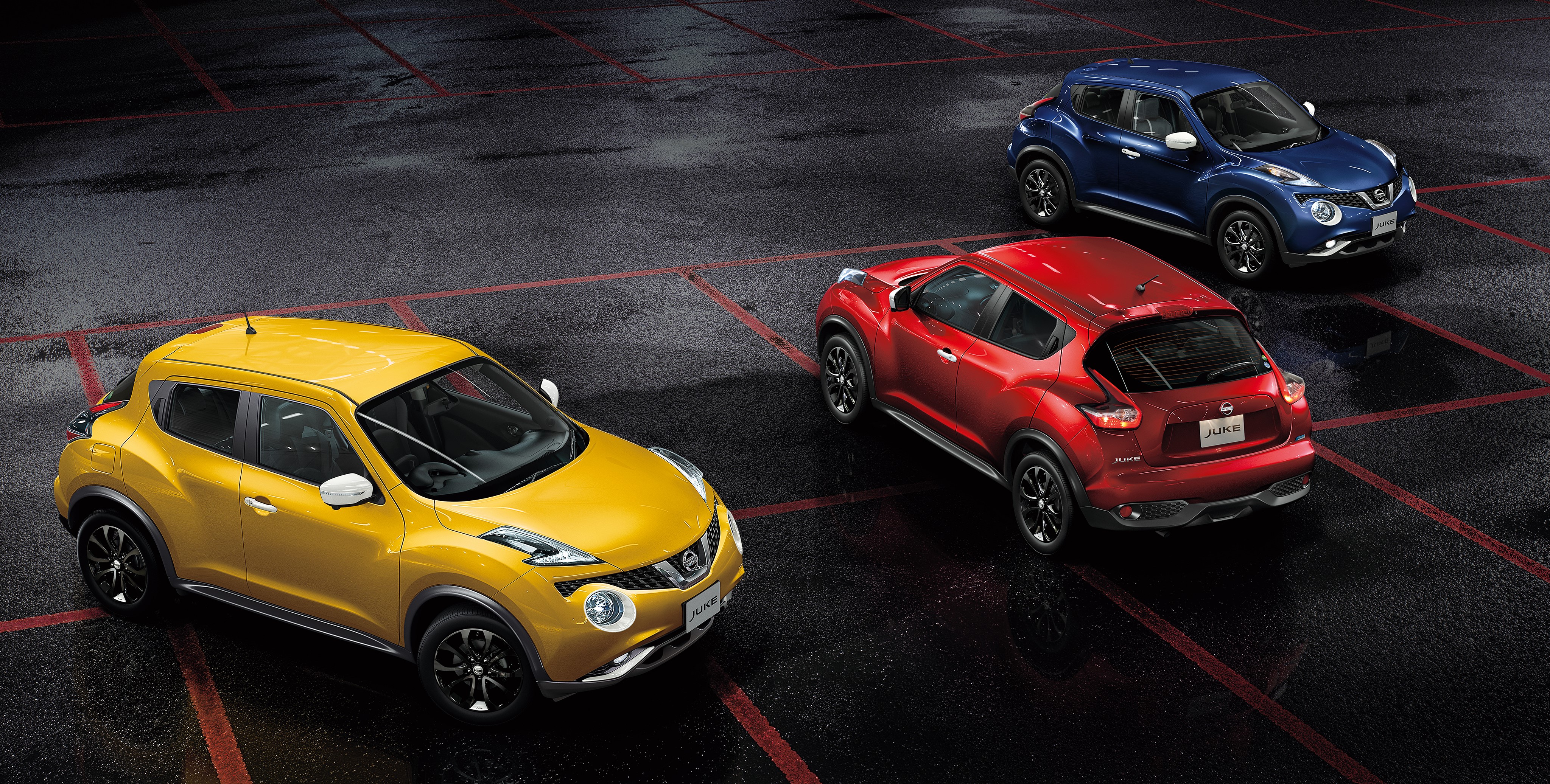 Three Nissan Juke cars in a parking lot HD Wallpaper