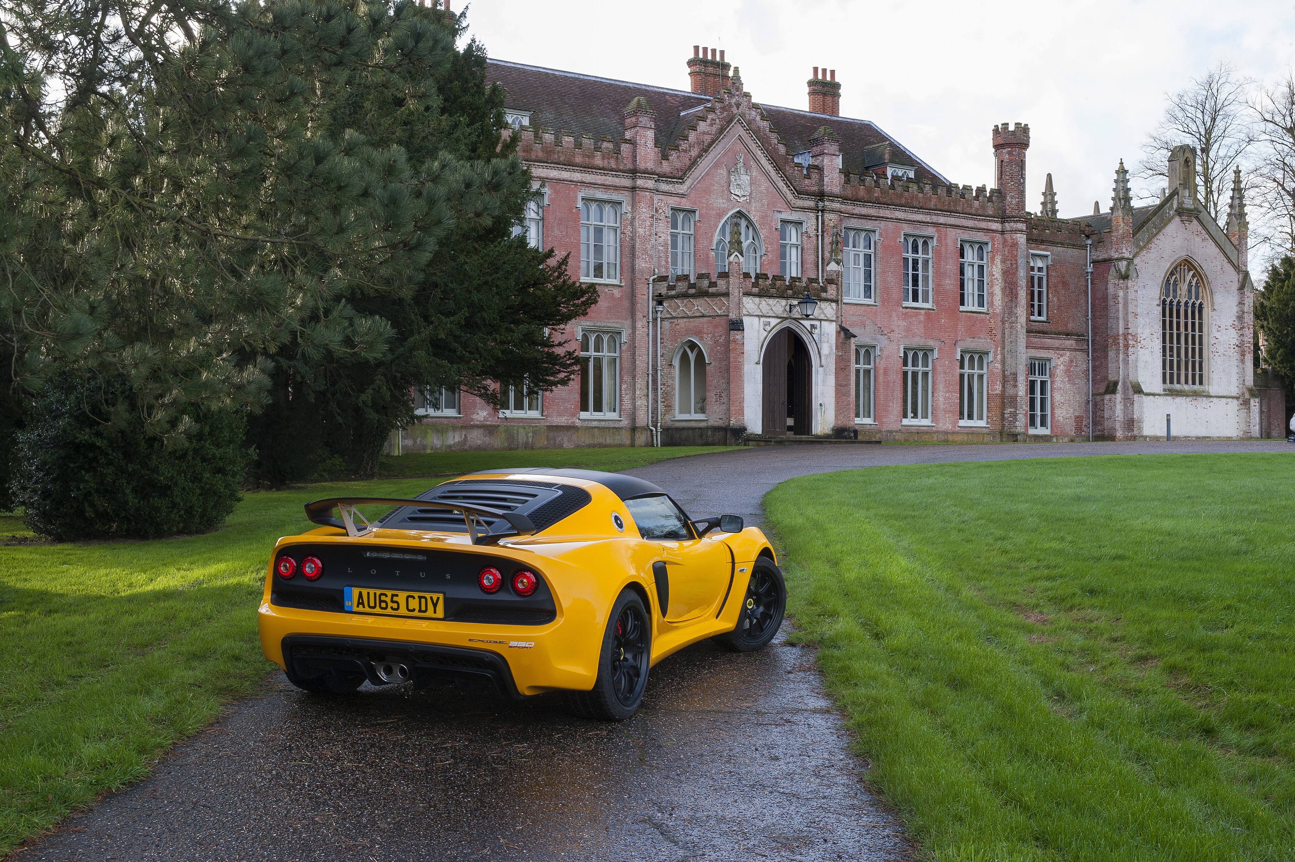 Yellow Lotus Exige Sport 350 in front of a manor HD Wallpaper