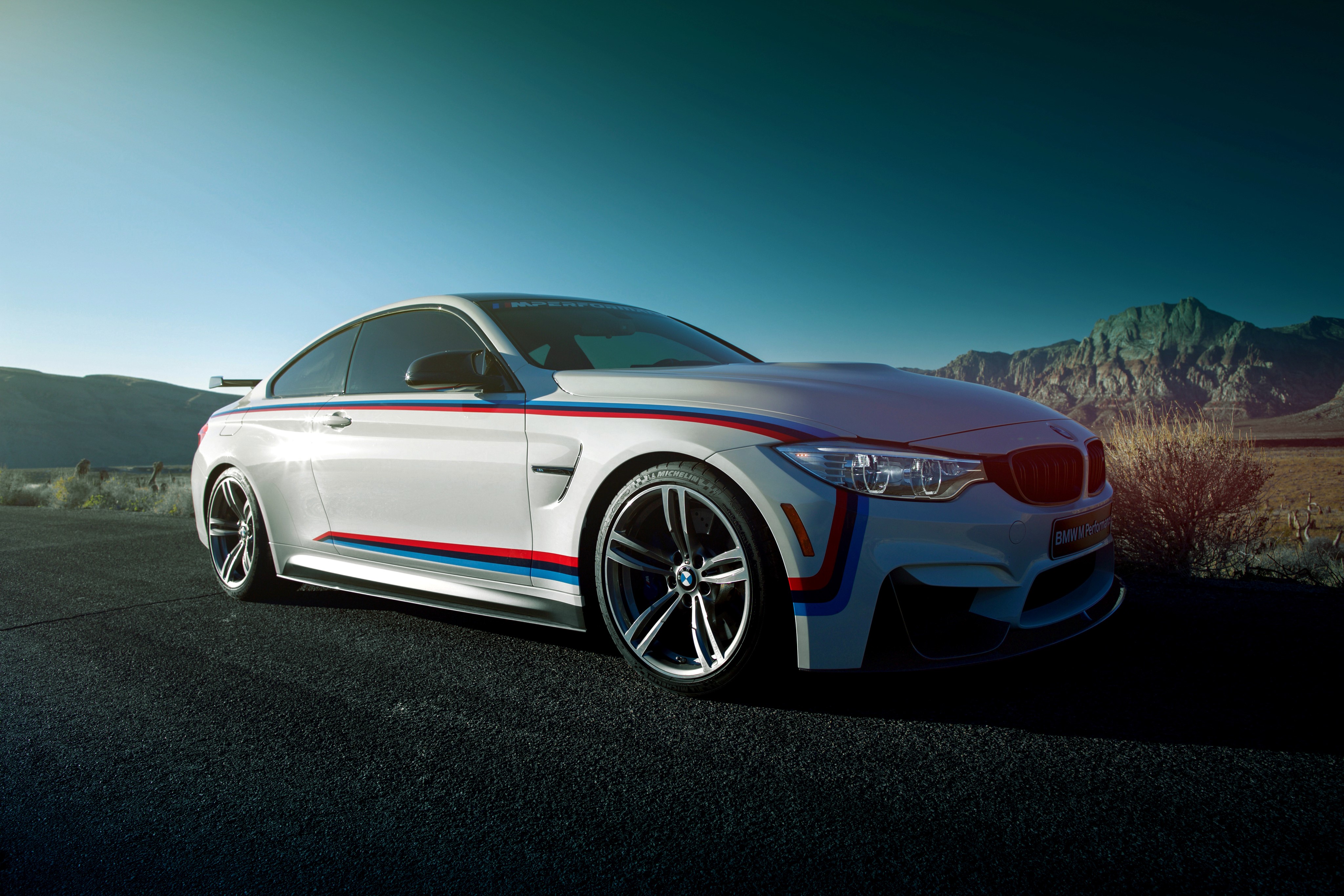 White BMW M4 Coupe with racing stripes HD Wallpaper