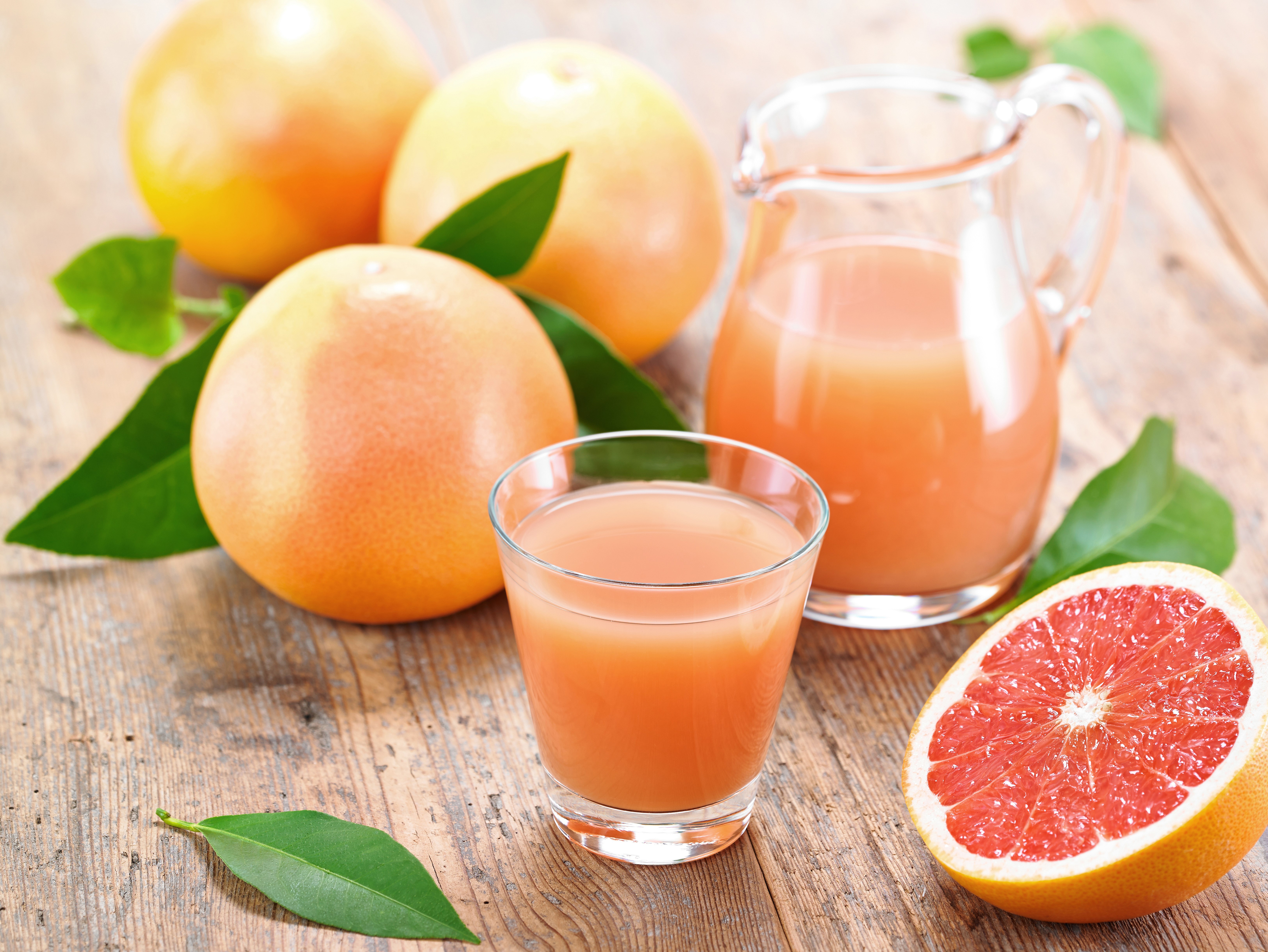 Grapefruit juice in a glass and pitcher with grapefruits HD Wallpaper