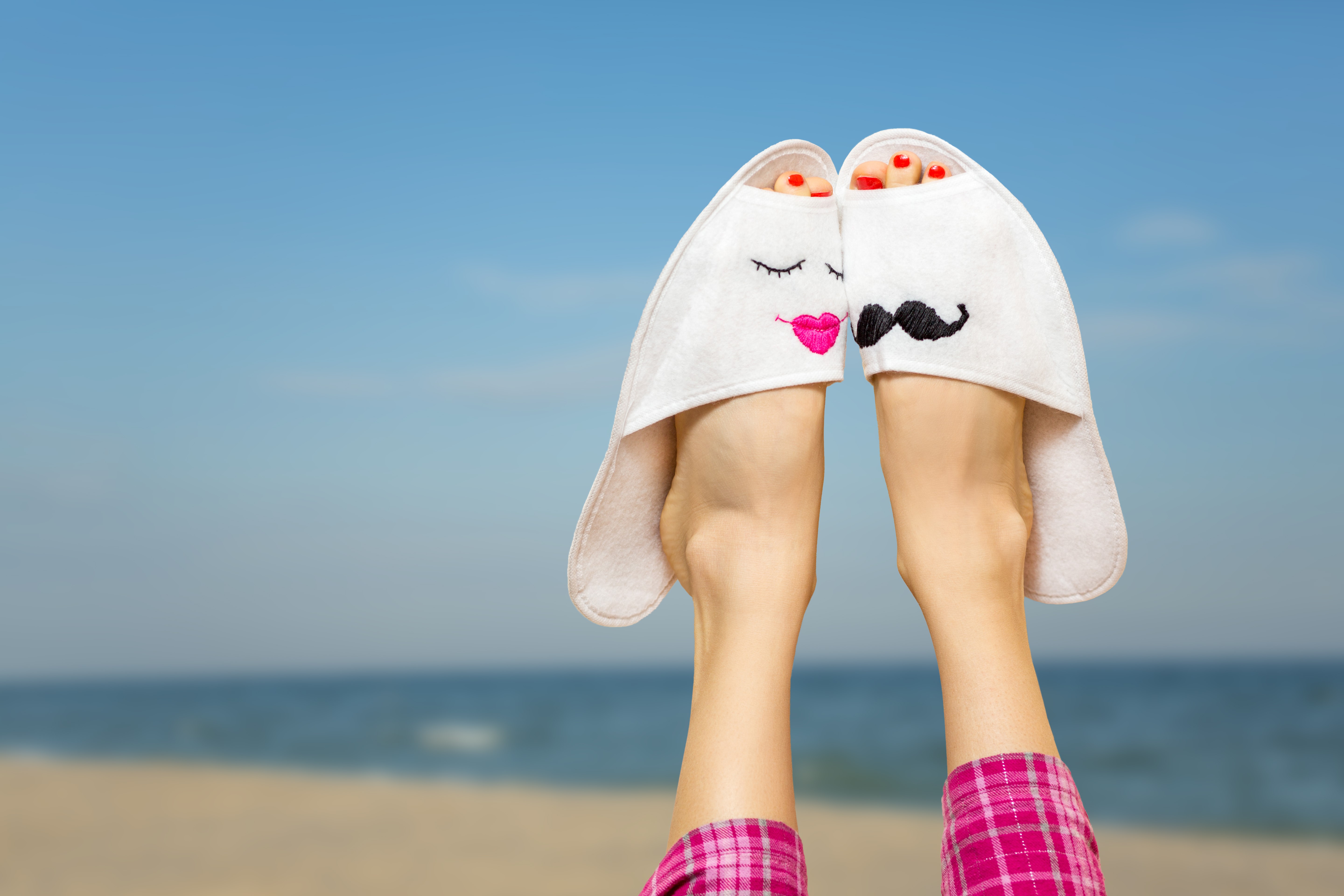 Couple's Slippers on Legs at Beach HD Wallpaper