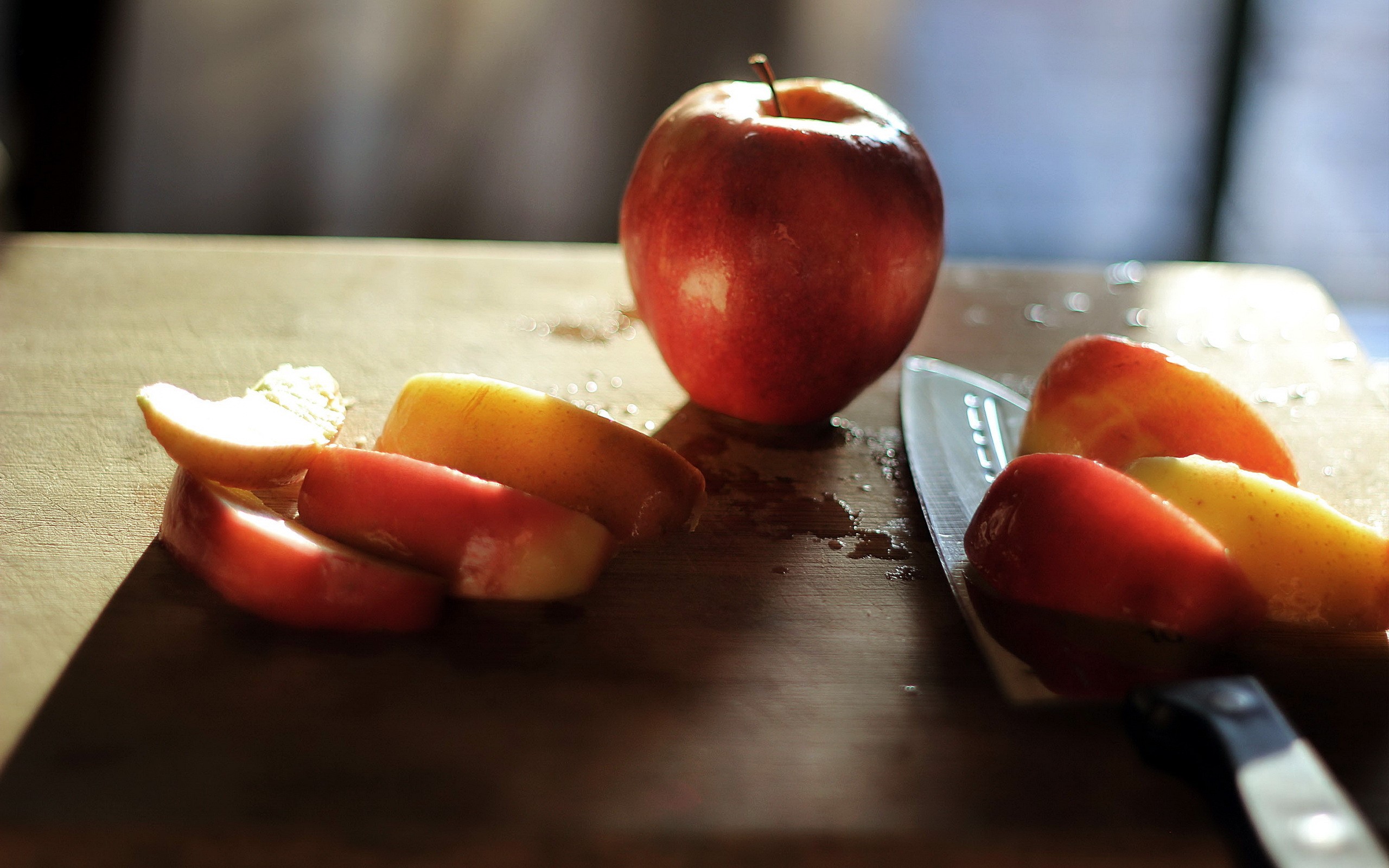 Apple slices and a knife on a cutting board HD Wallpaper