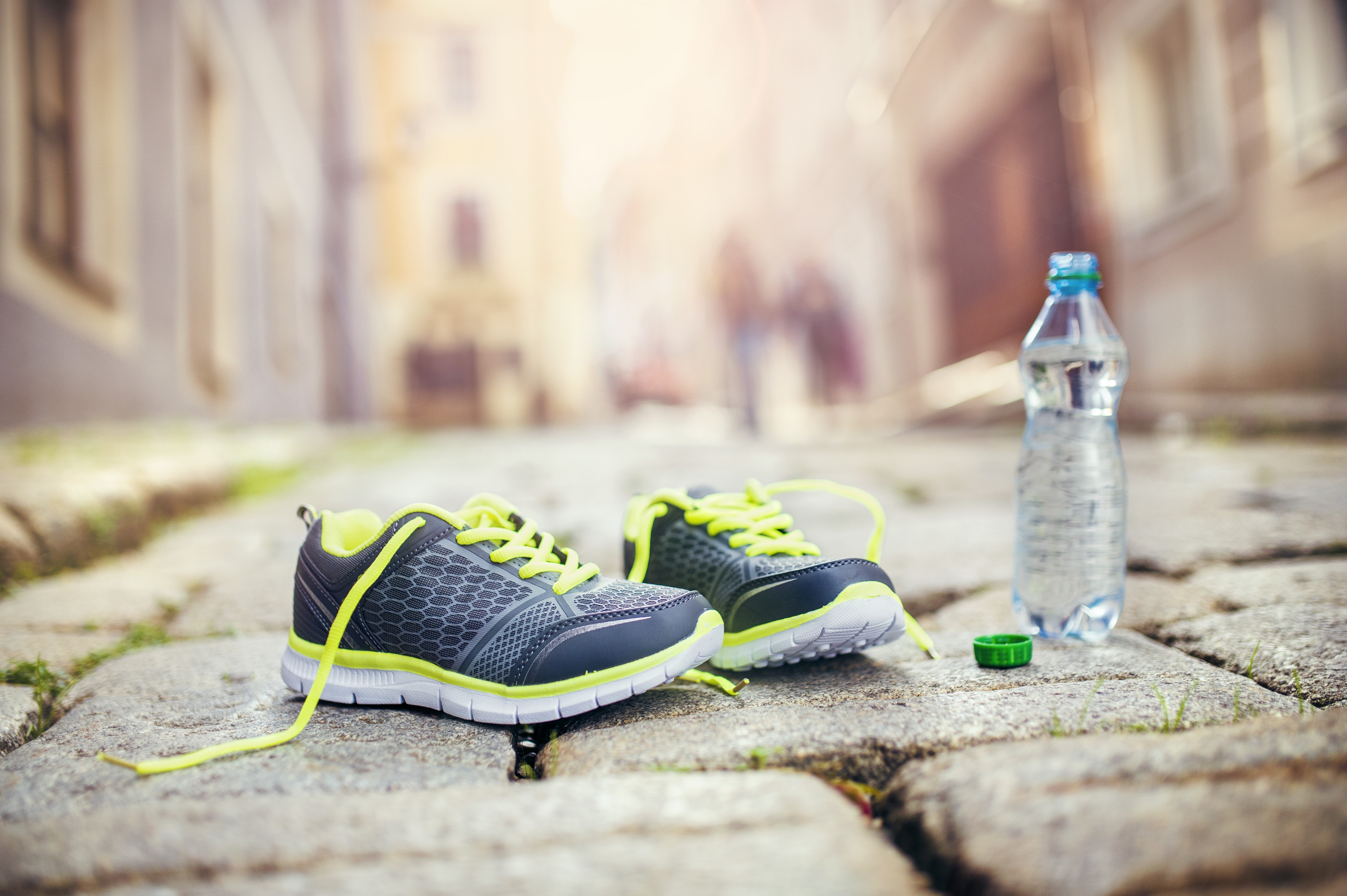 Athletic shoes and water bottle on pavement HD Wallpaper