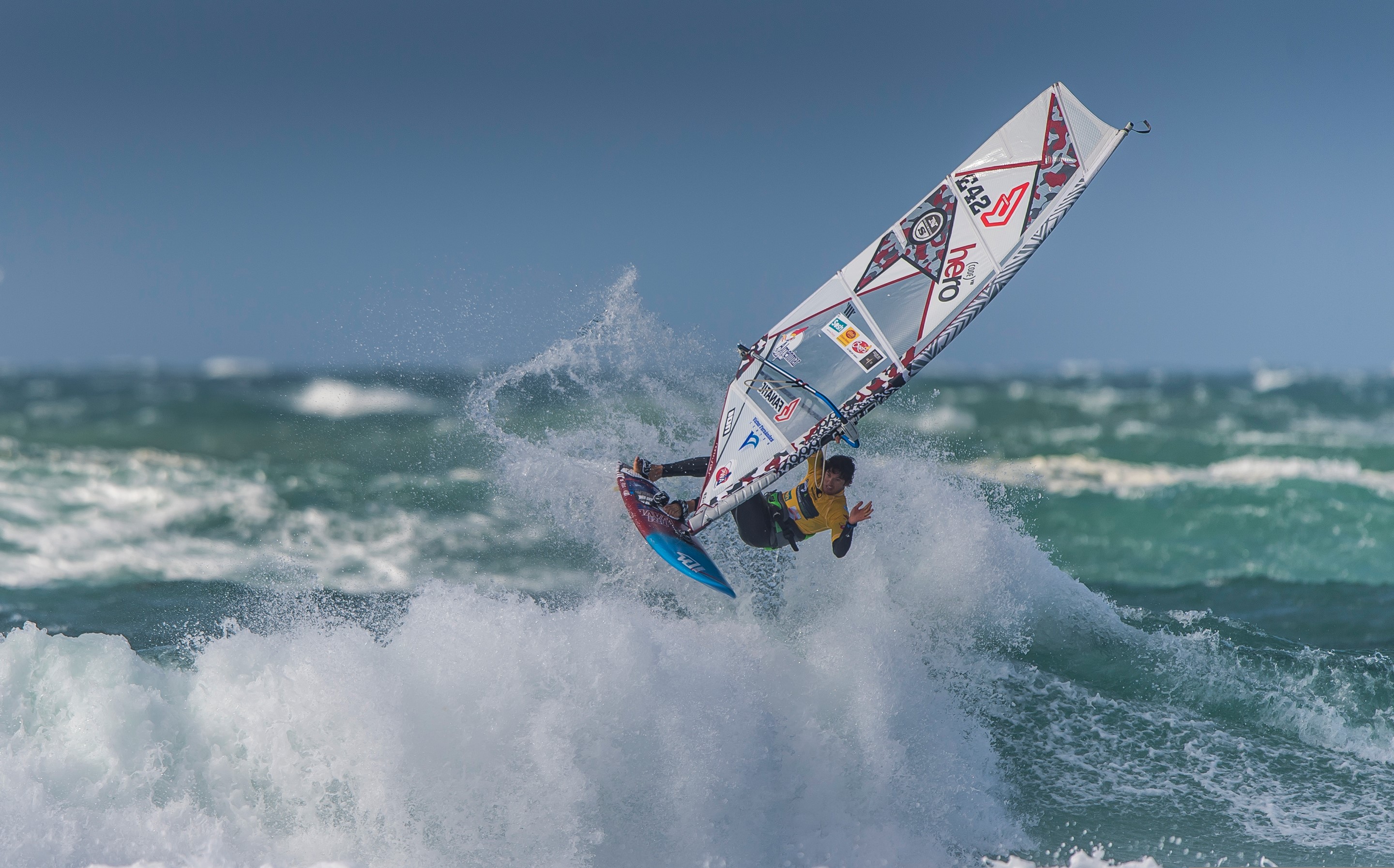 Windsurfer performing a jump over a wave HD Wallpaper