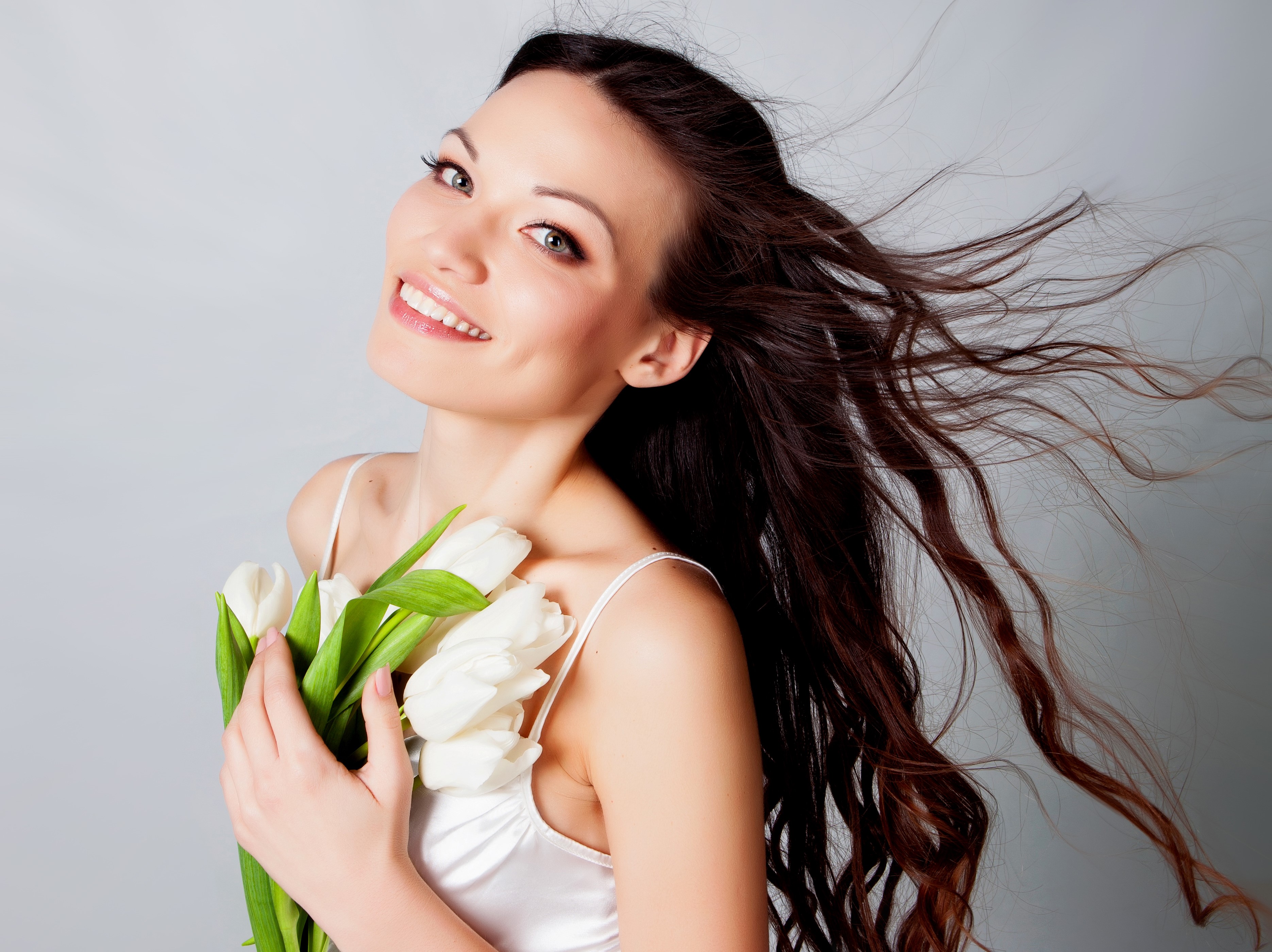 Woman with brown hair holding white tulips HD Wallpaper
