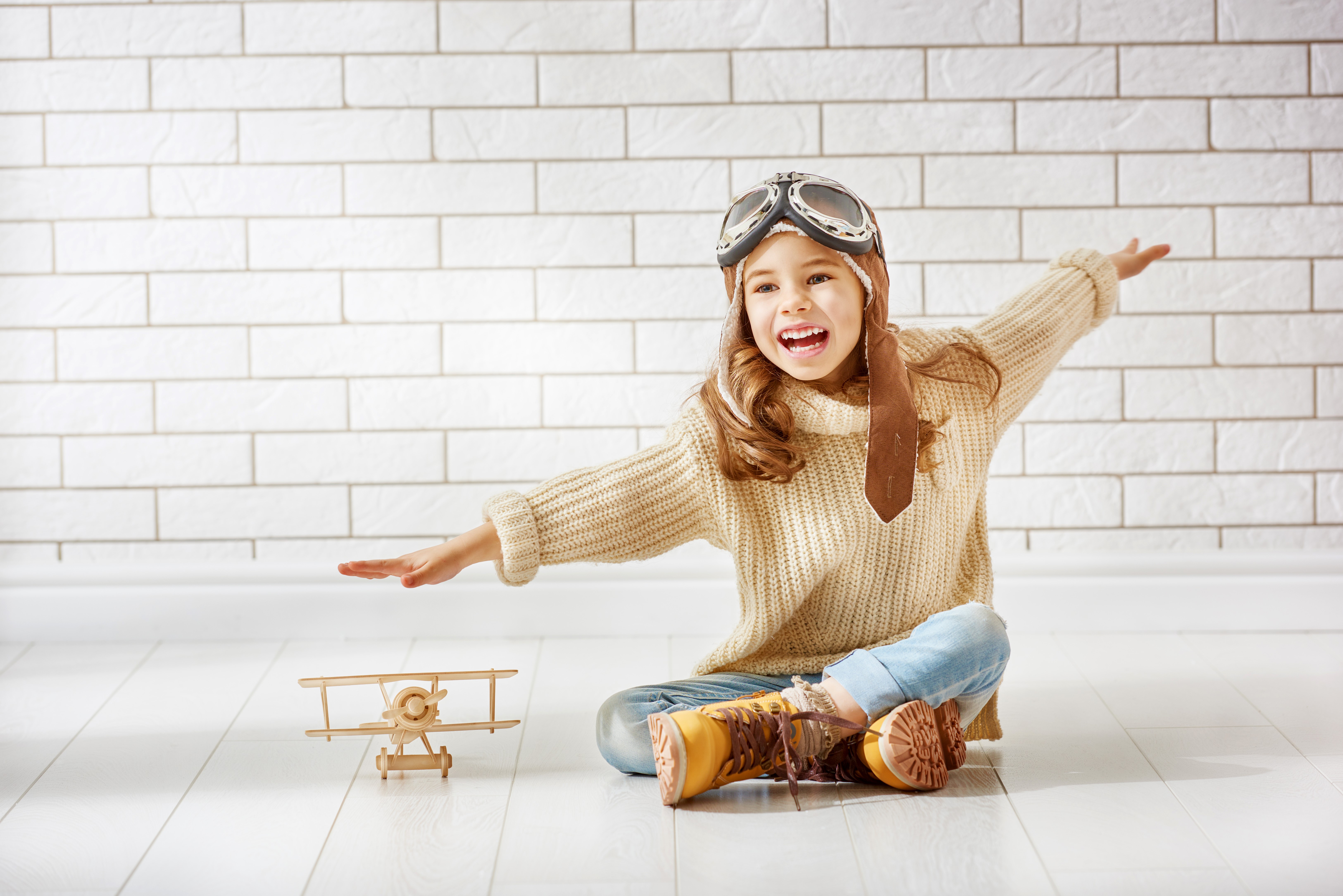 Girl in pilot costume with toy airplane HD Wallpaper