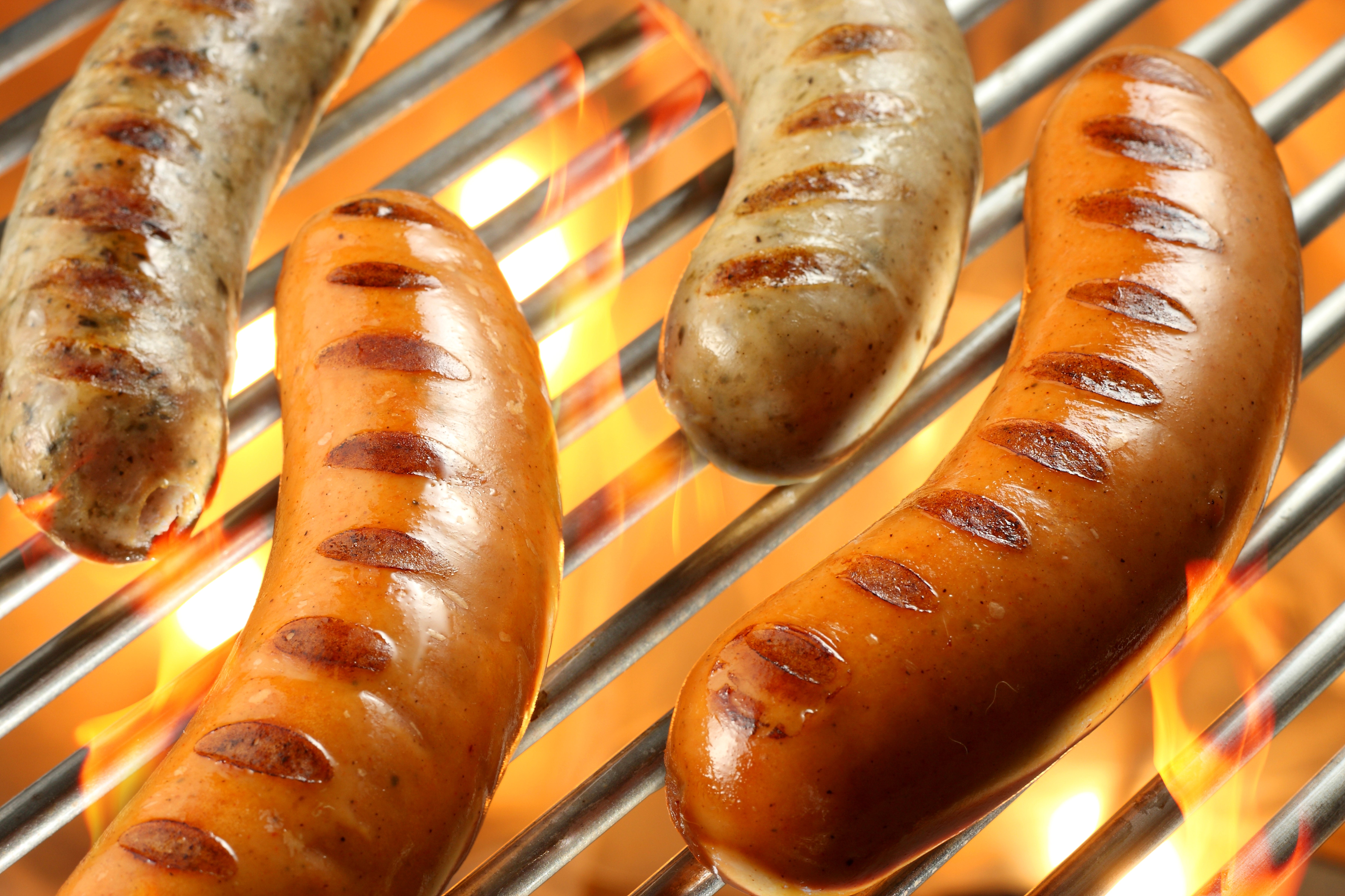 Sausages grilling over flames HD Wallpaper