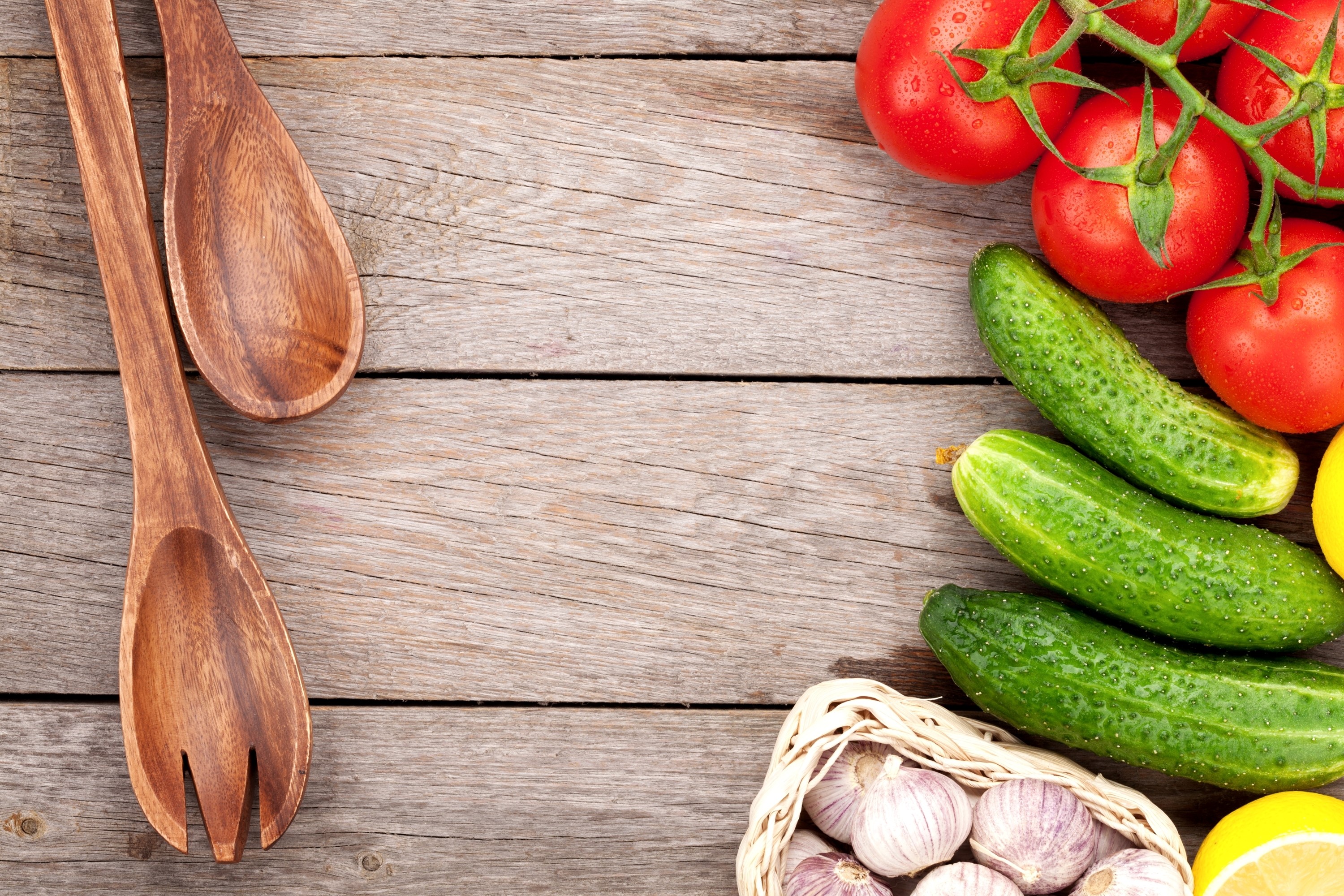 Tomatoes, cucumbers, garlic, and wooden spoons on wood planks HD Wallpaper