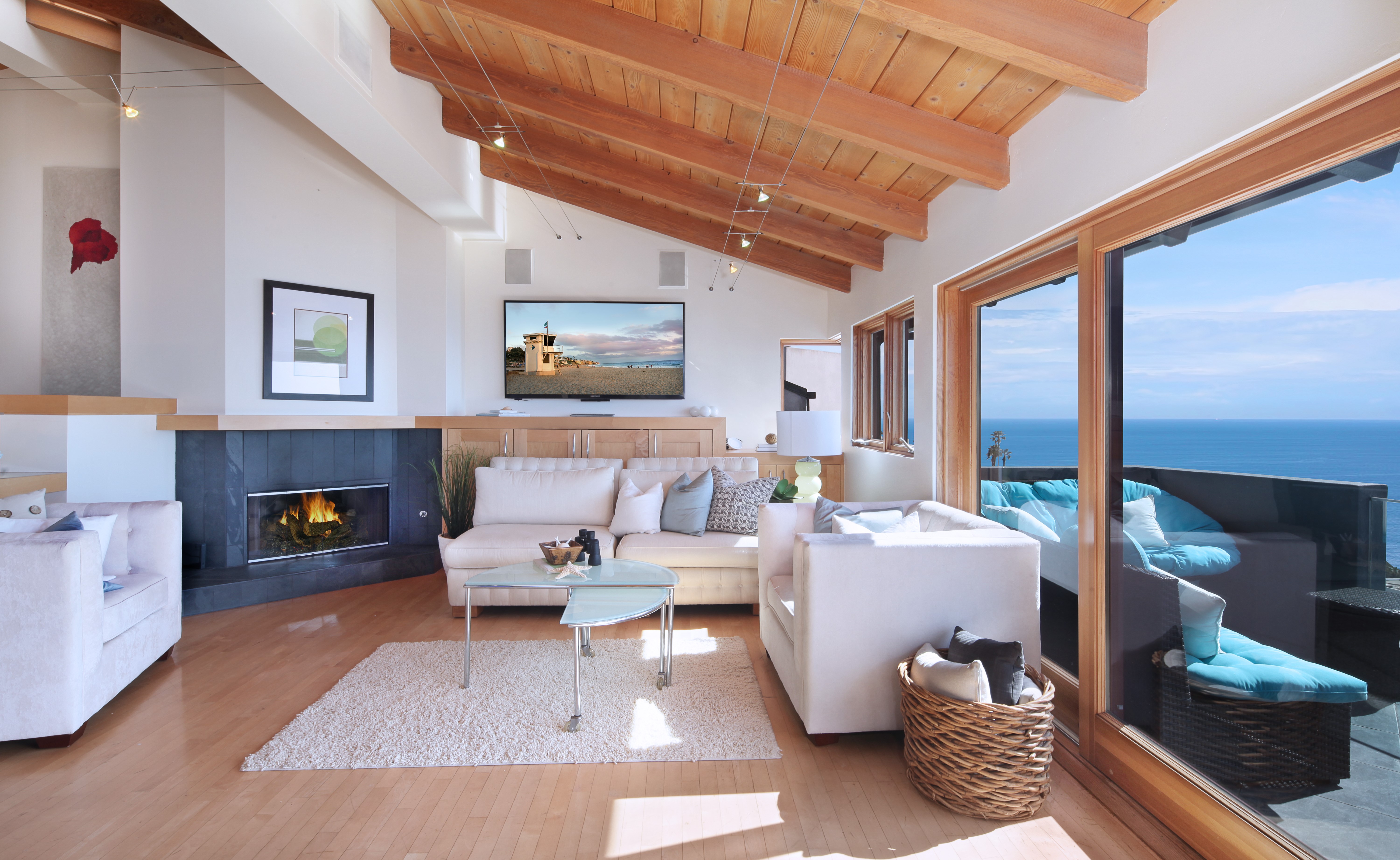 Living room with fireplace, sofa, and ocean view HD Wallpaper