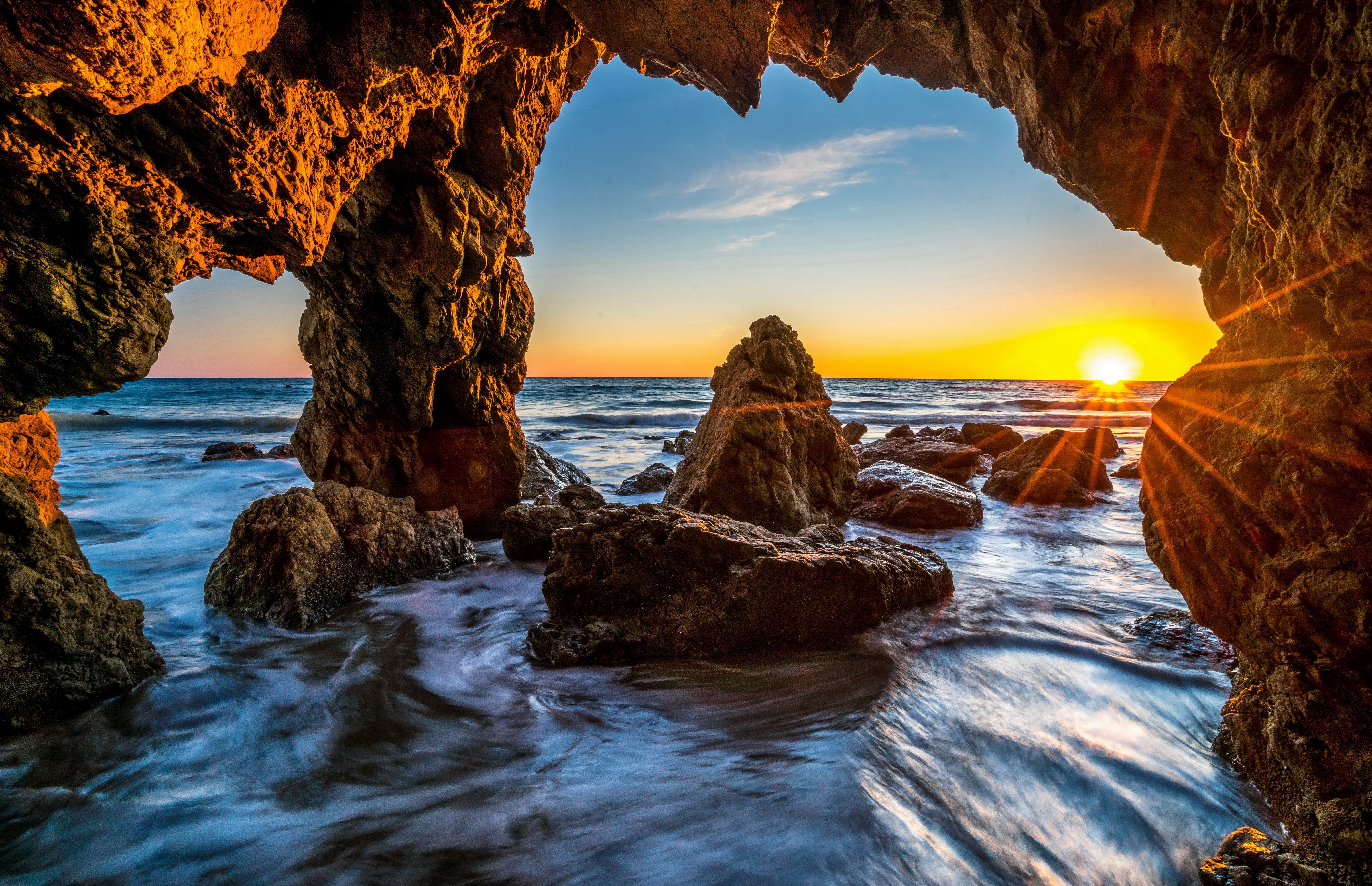 Sunset through a cave at Malibu, USA HD Wallpaper