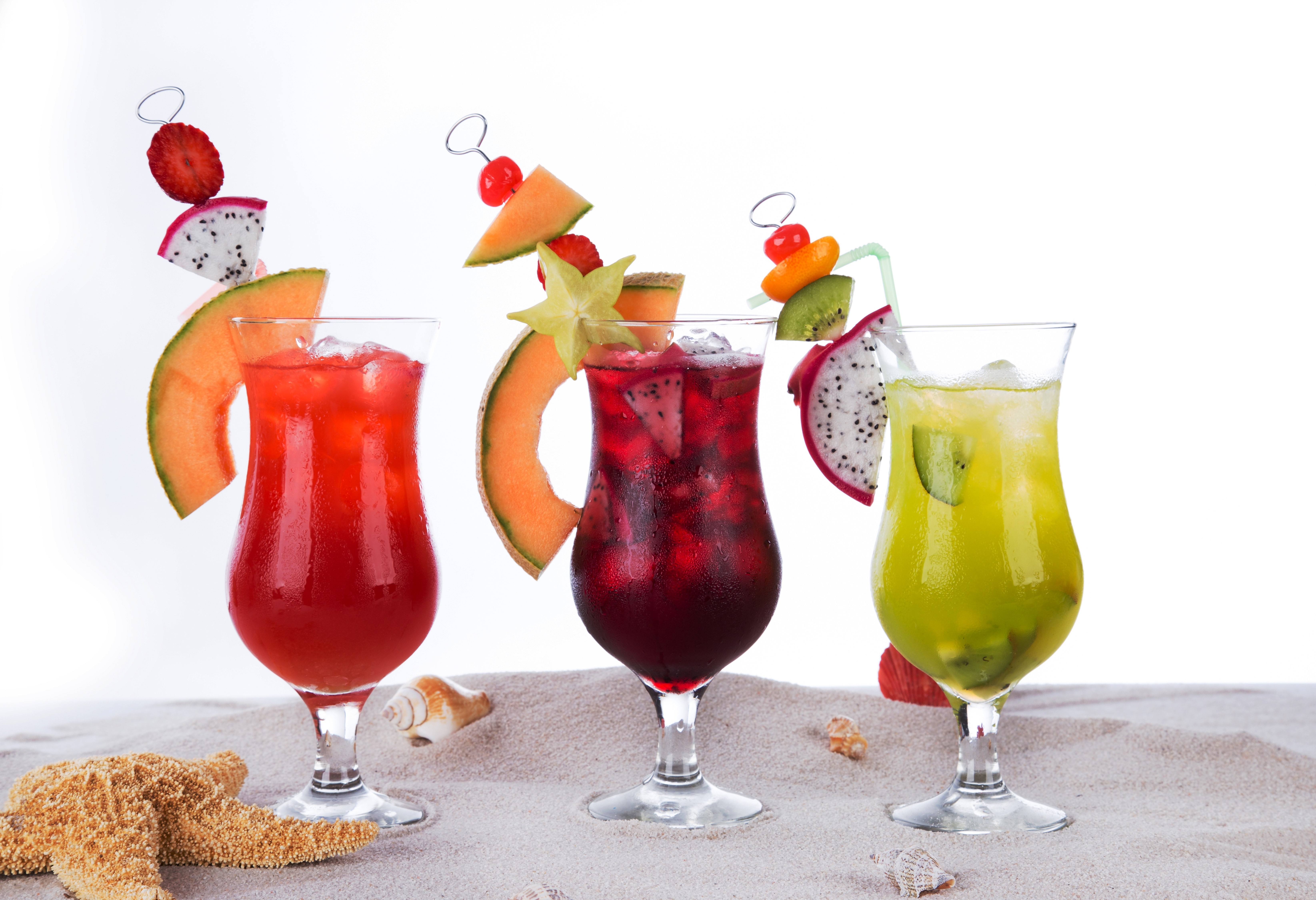Three tropical cocktails on a sandy beach HD Wallpaper