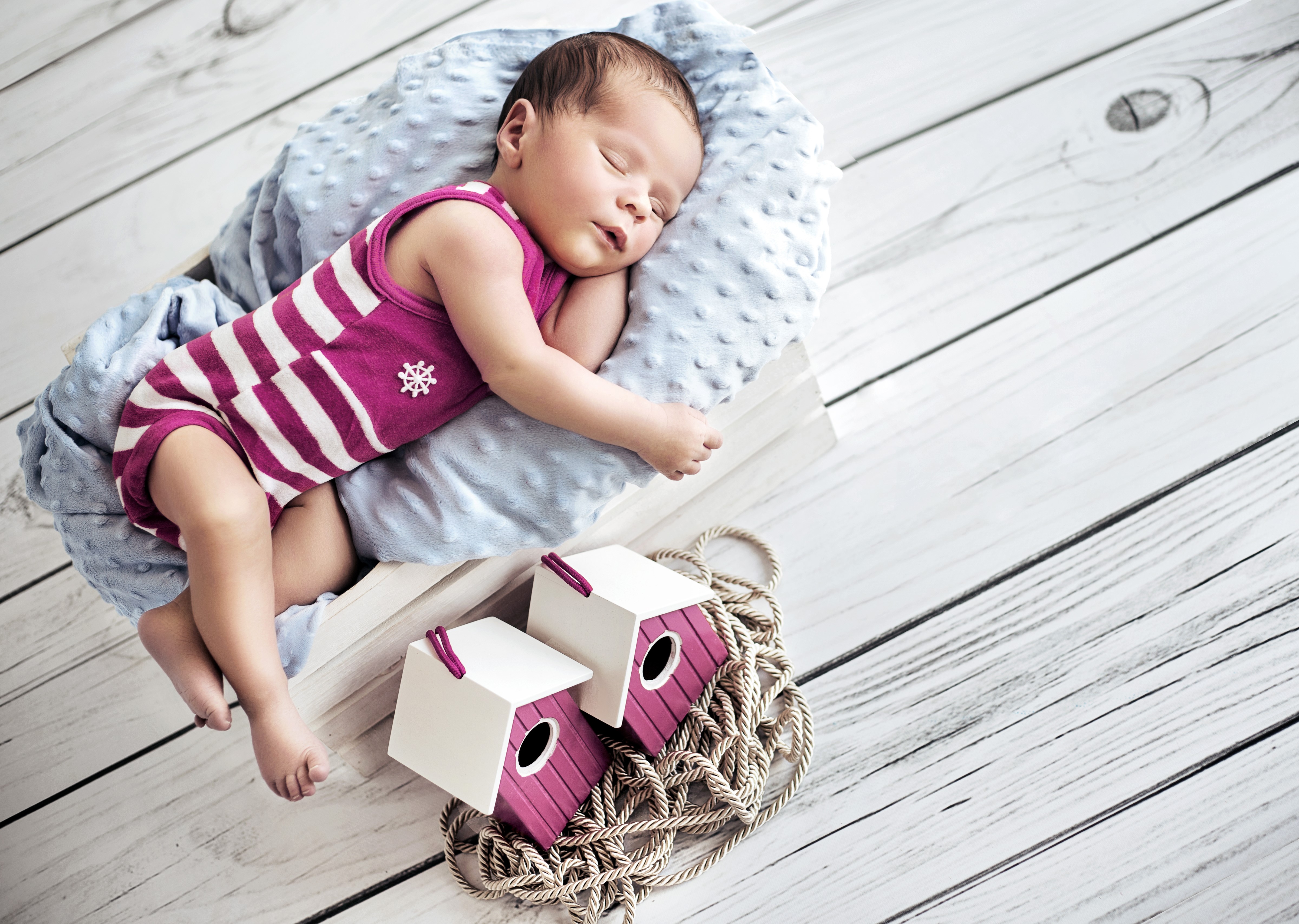 Newborn baby sleeping in a basket with birdhouses HD Wallpaper
